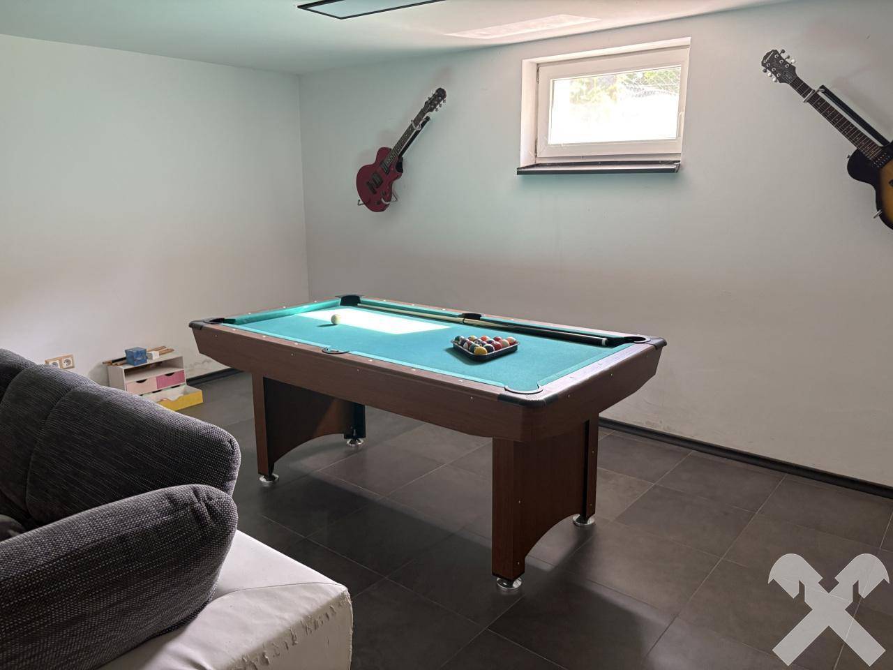 Spielzimmer mit Billardtisch und Gitarren an der Wand, ideal für Unterhaltung und Freizeitaktivitäten.