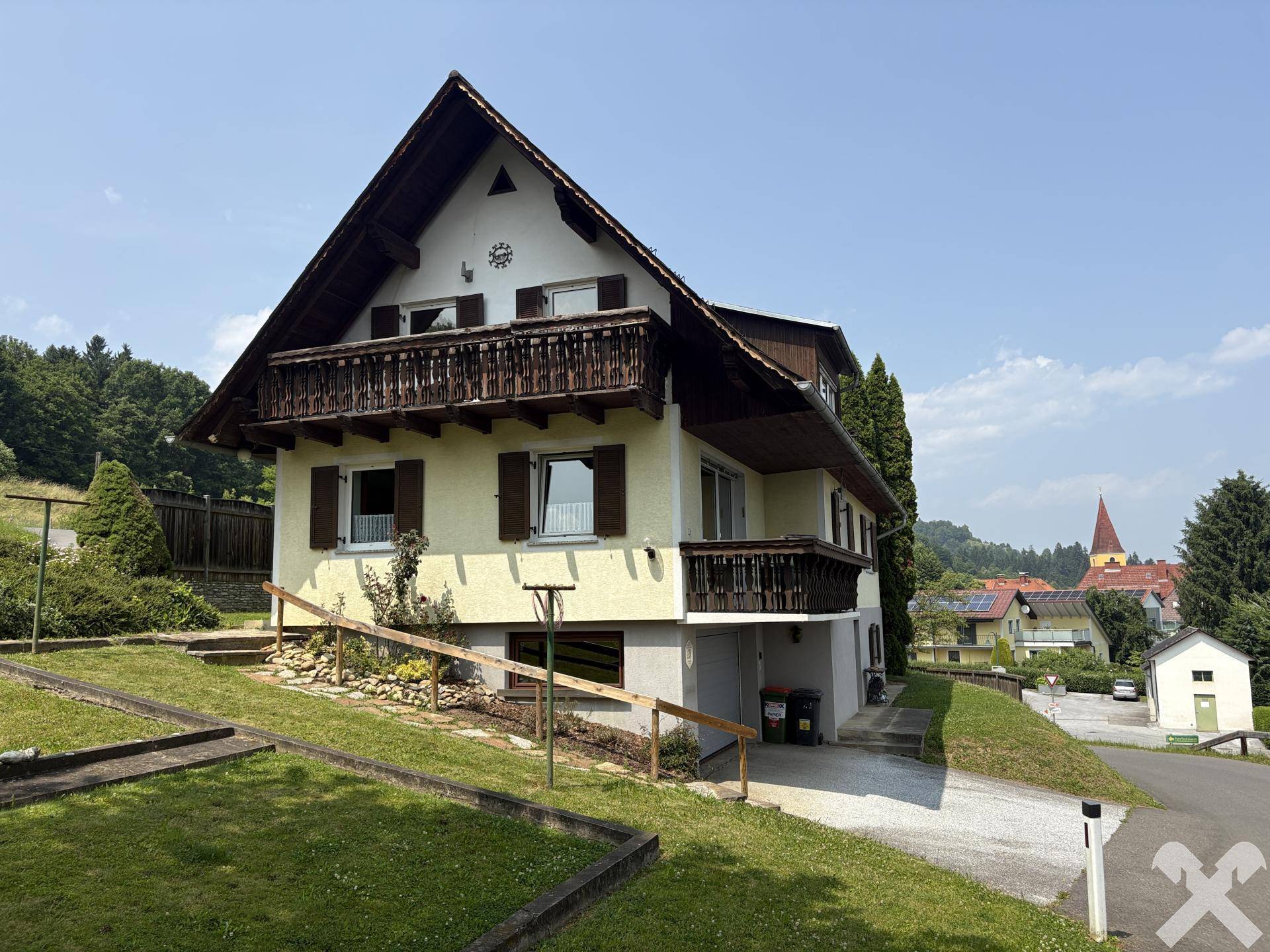 Freistehendes Haus mit mehreren Balkonen und Blick auf die umliegende Landschaft und ein Dorf.