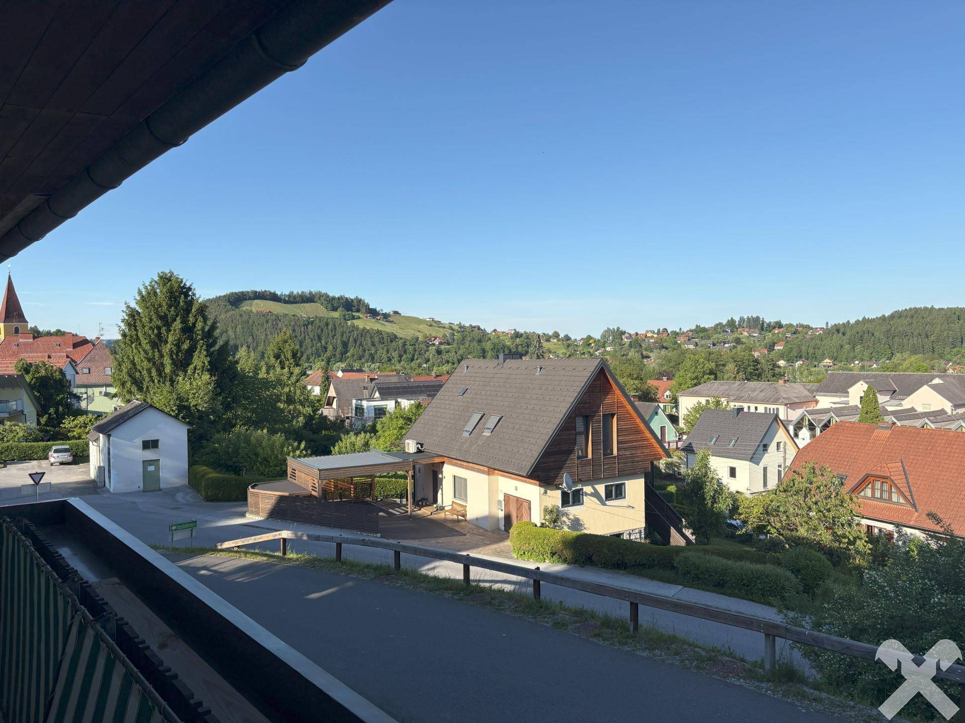Weitläufiger Blick über die Dächer der Nachbarschaft und die grüne Hügellandschaft.