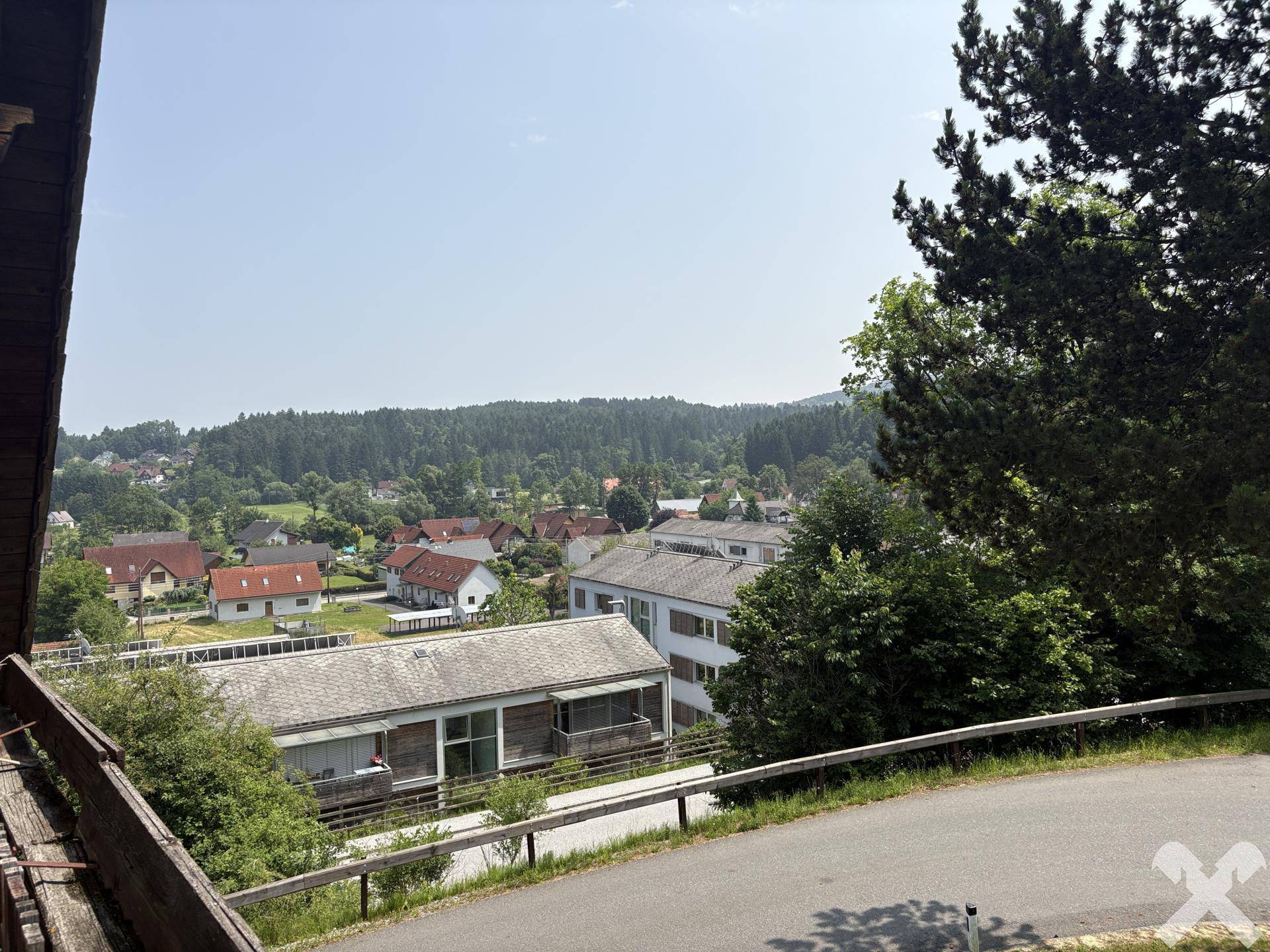 Ausblick von der Terrasse auf die Nachbarschaft und die bewaldeten Hügel in der Ferne.