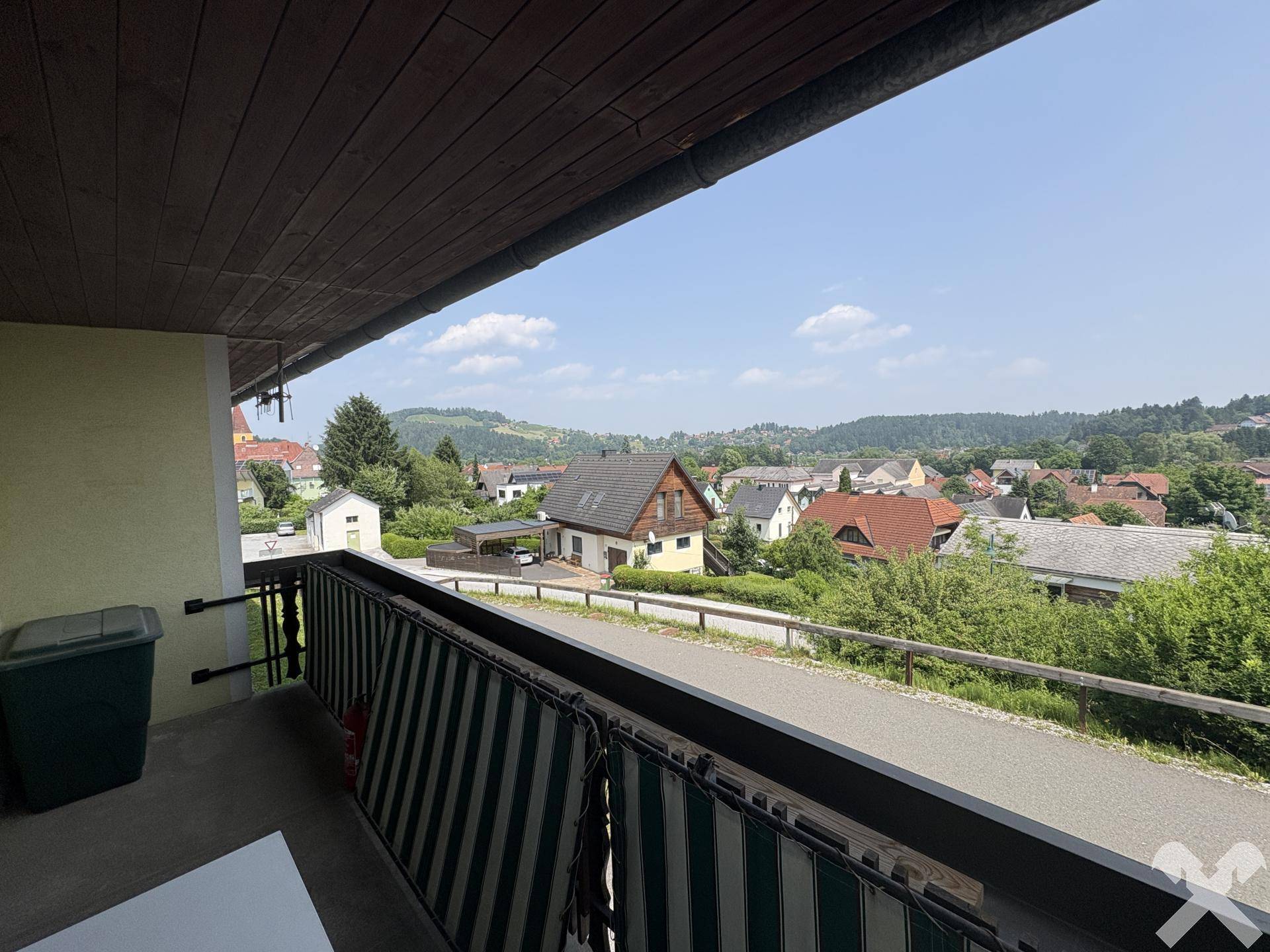 Balkon mit Blick auf die umliegende Wohngegend und die grüne Natur.