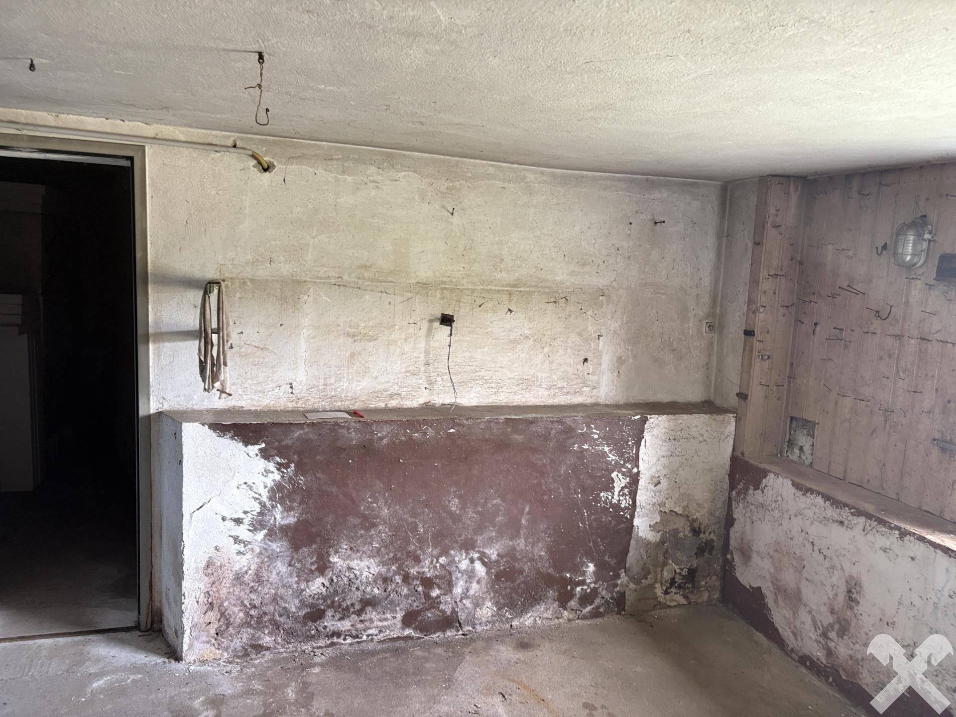 Unausgebauter Kellerraum mit rauen Wänden und Betonboden, ideal als Abstellraum.