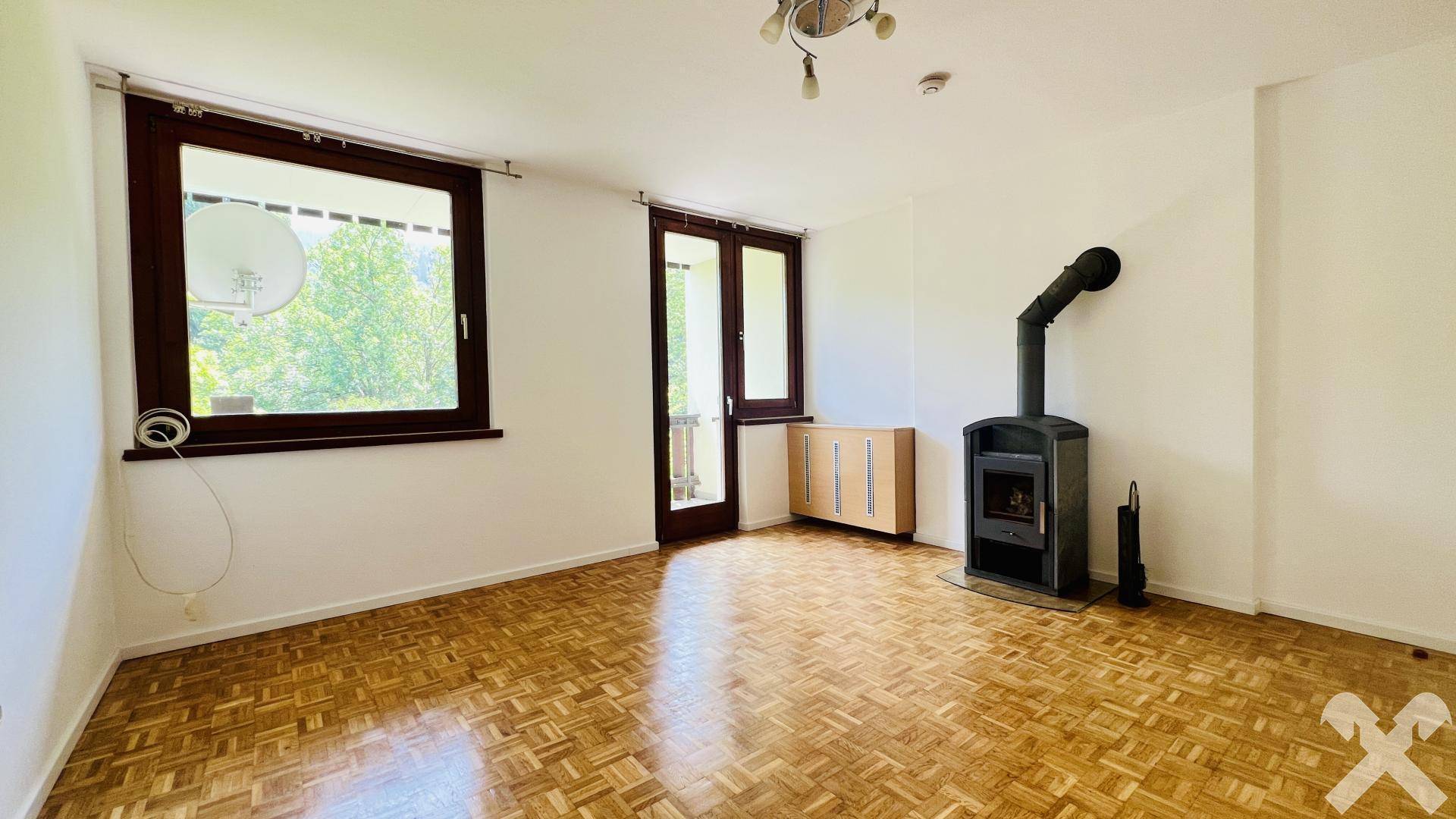 Wohnzimmer mit Kaminofen und Zugang Loggia