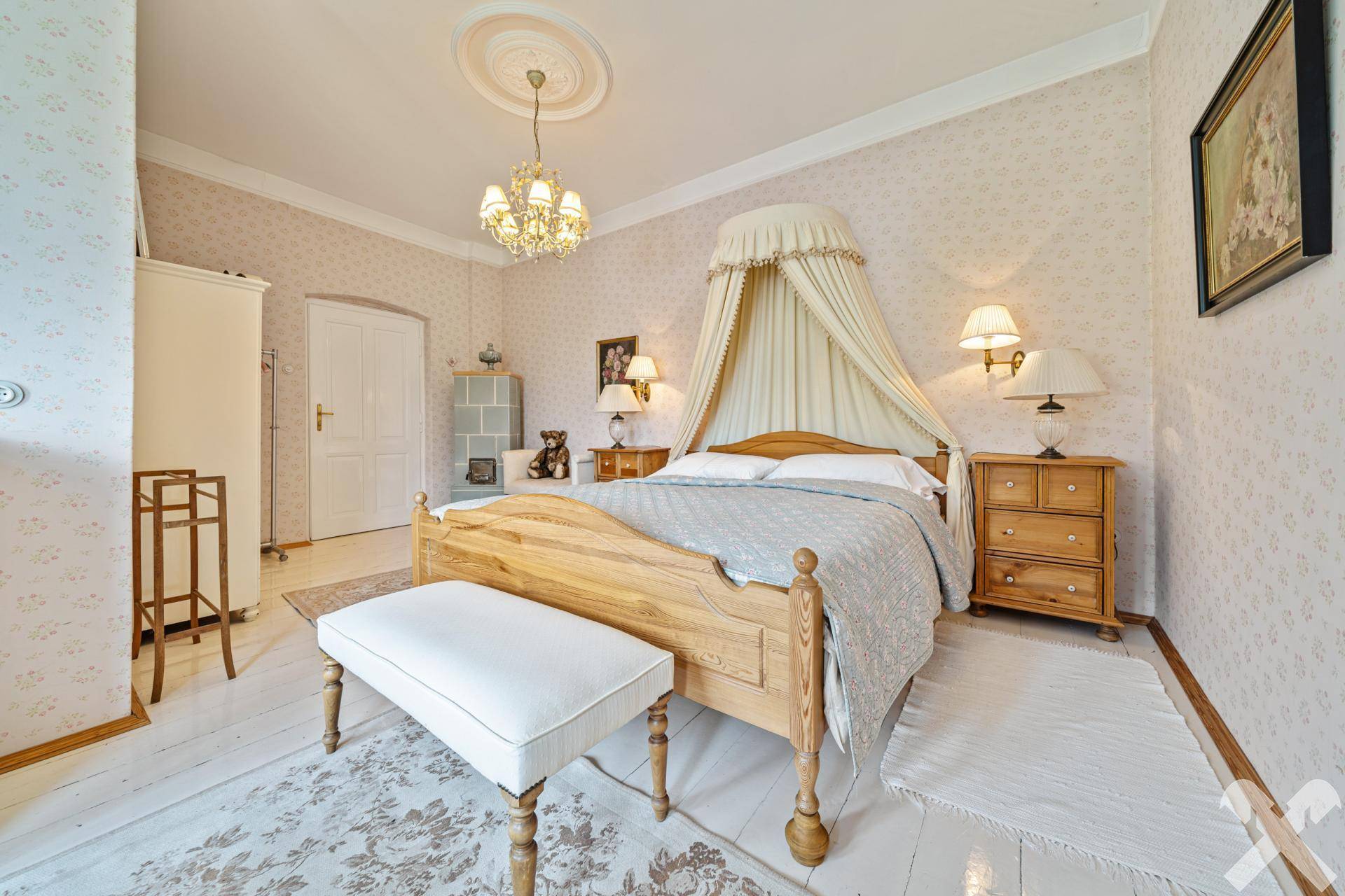 Helles Schlafzimmer mit Himmelbett, Holzboden und traditioneller Einrichtung in Pastelltönen.