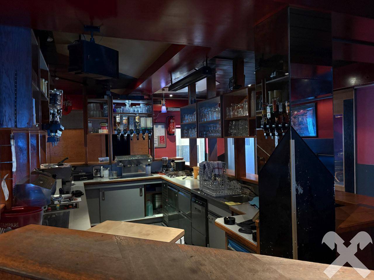 Servicebereich hinter der Bar mit Zapfanlagen, Spülbecken und Regalen für Gläser.