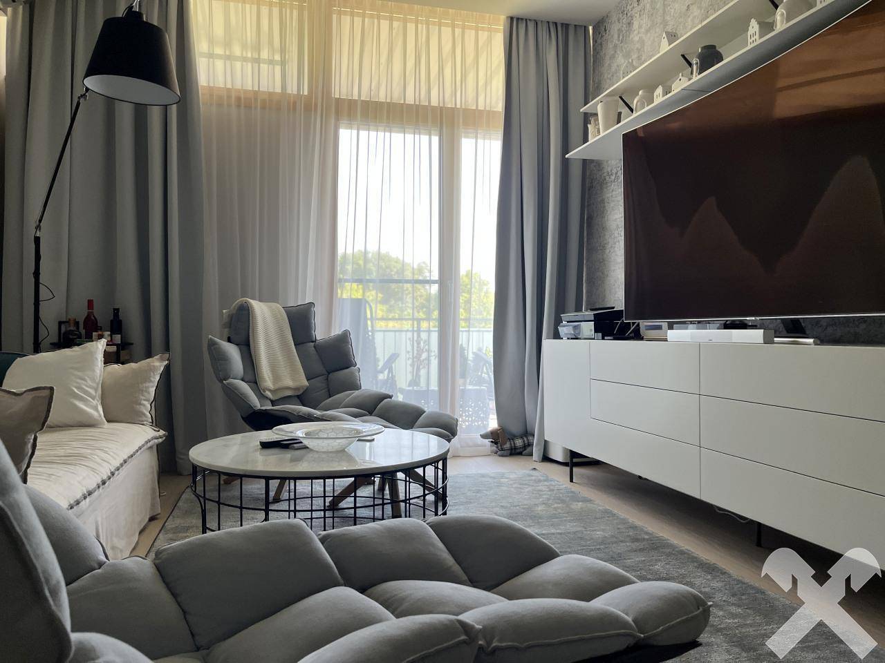 Gemütliches Wohnzimmer mit bequemen Sitzgelegenheiten, Couchtisch und Blick ins Grüne.