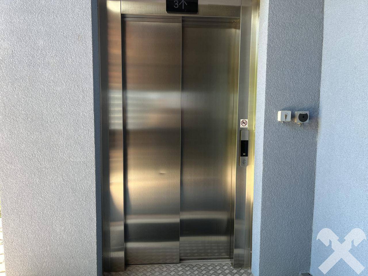 Moderner Aufzug im Gebäude mit Edelstahltüren und Zugang zu den oberen Etagen.