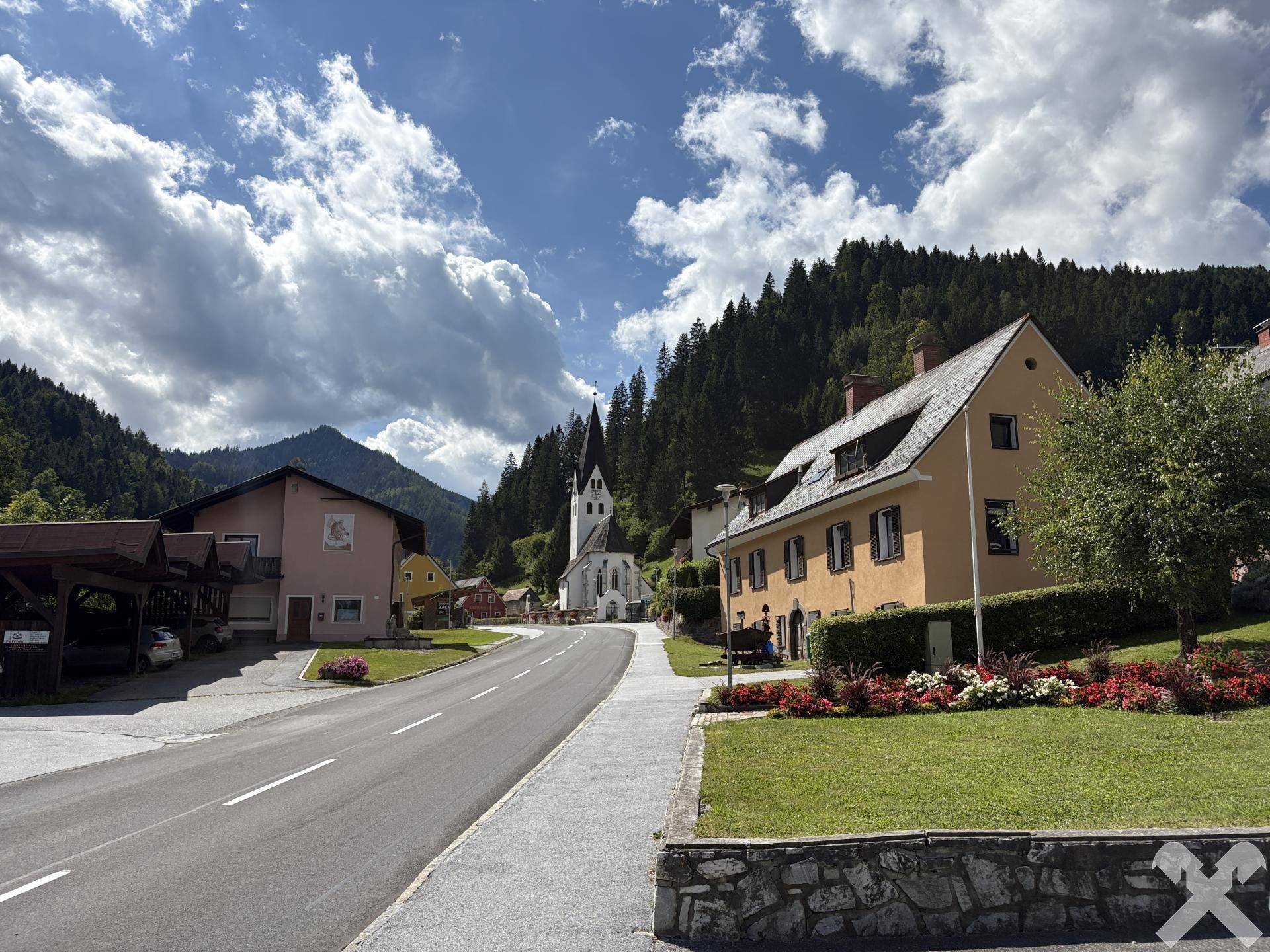 Panoramablick auf die Straße, umliegende Häuser und die bergige Landschaft.