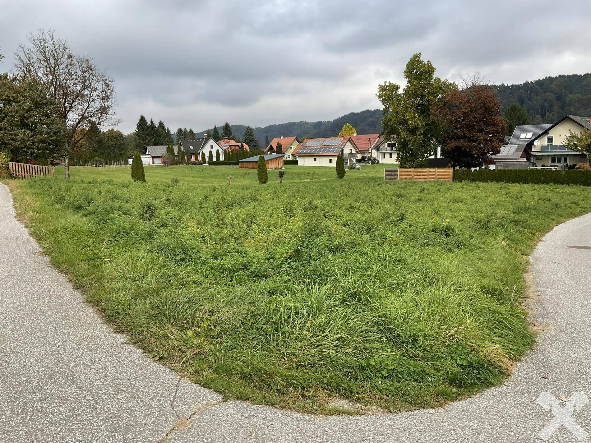 Großes grünes Grundstück an einer Gabelung mit Blick auf die ländliche Umgebung.