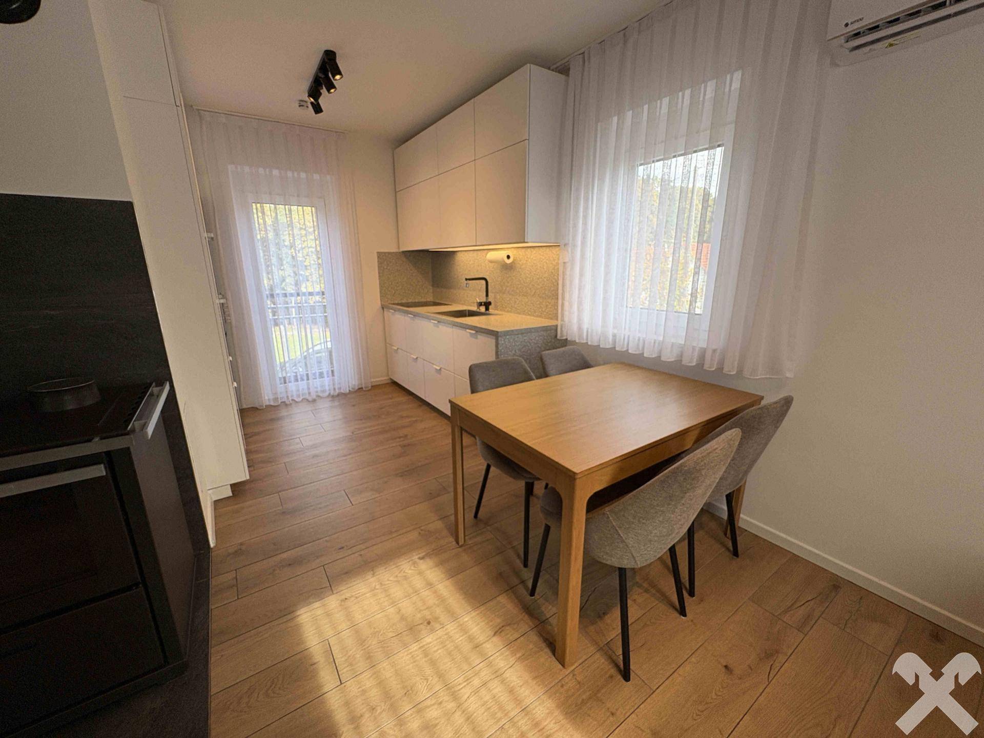Essbereich mit Holztisch und Stühlen, angrenzend an die moderne Küche.