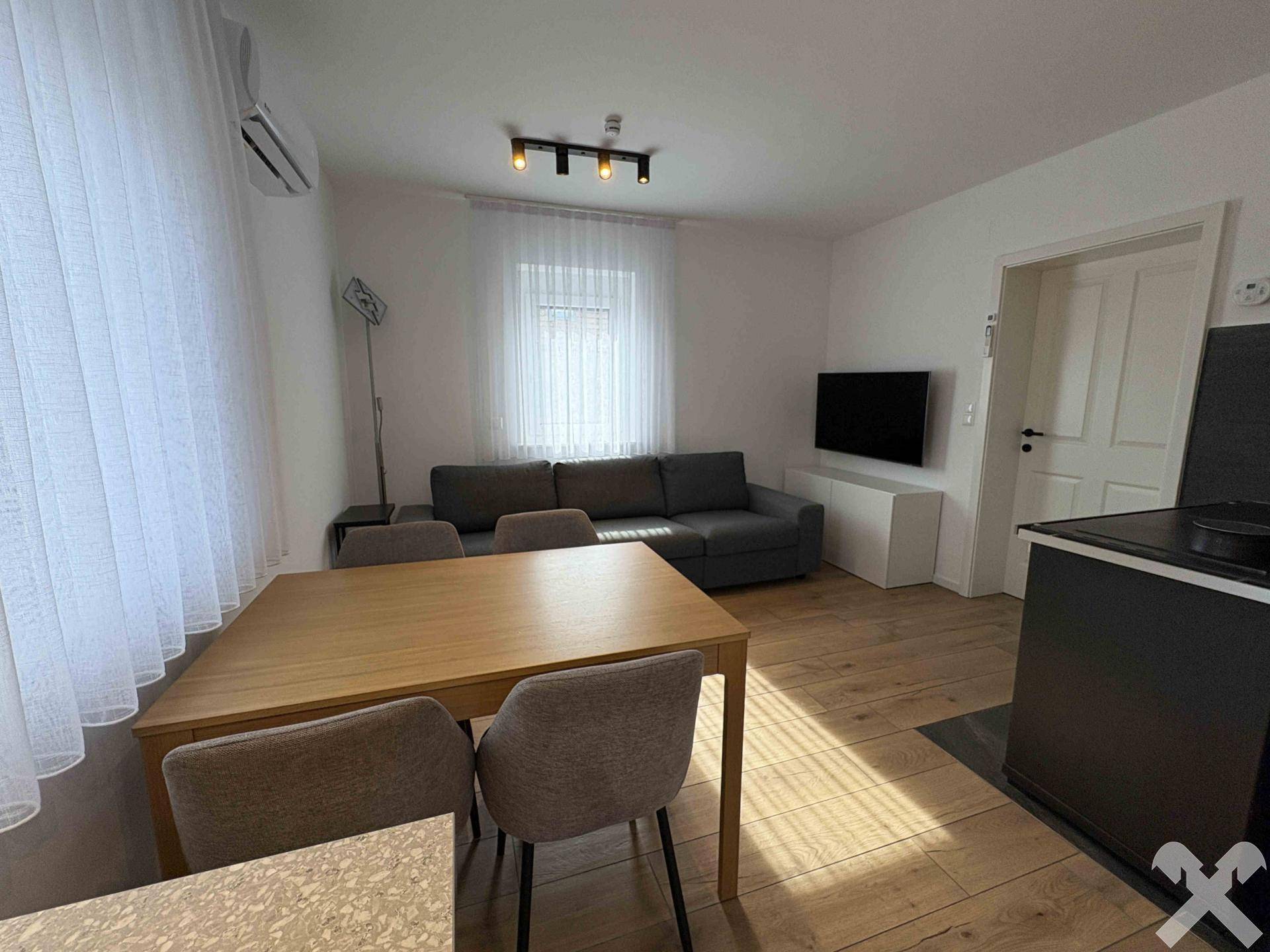 Heller Wohnbereich mit Sofa, Esstisch und Klimaanlage, ideal für entspannte Stunden.