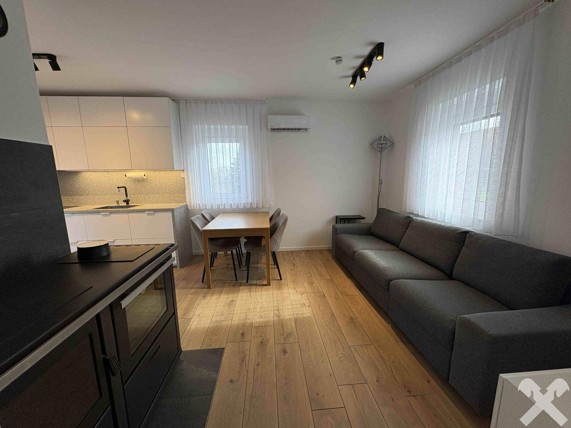 Geräumiger offener Wohnbereich mit moderner Küche, Esstisch und bequemer Couch.