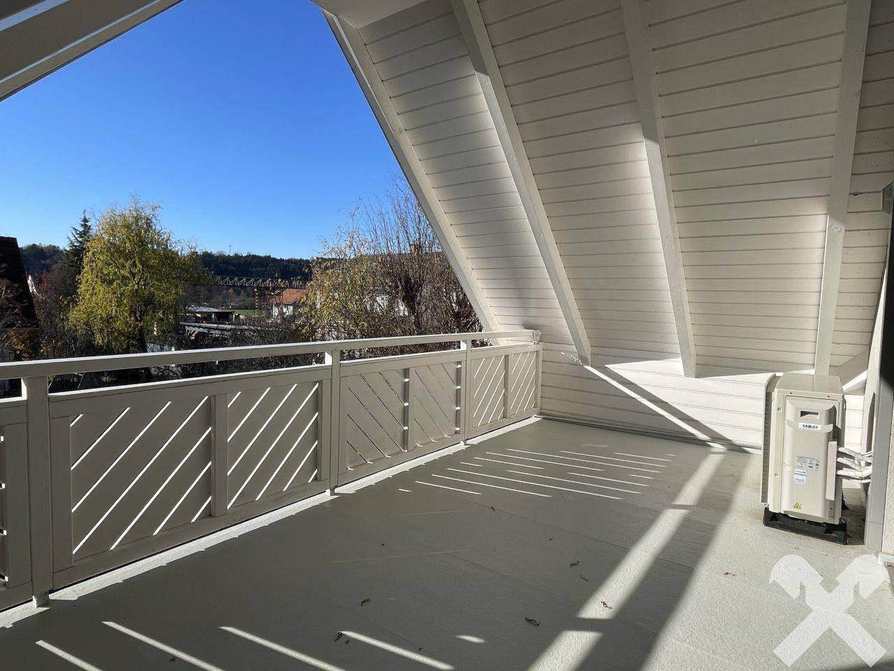 Geräumiger Balkon mit weißem Geländer und weitem Blick in die Umgebung.