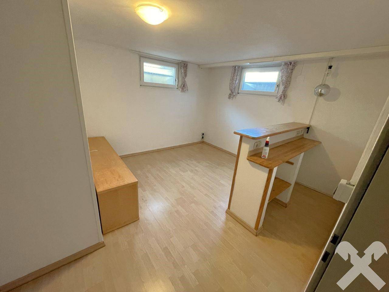 Ausgebauter Kellerraum mit Laminatboden und kleiner Bar, vielseitig nutzbar.