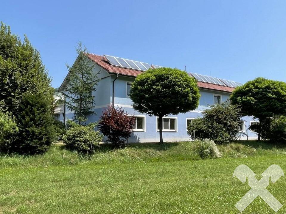 Seitenansicht des Gebäudes mit Solaranlage und weitem Blick auf die umliegende Natur.