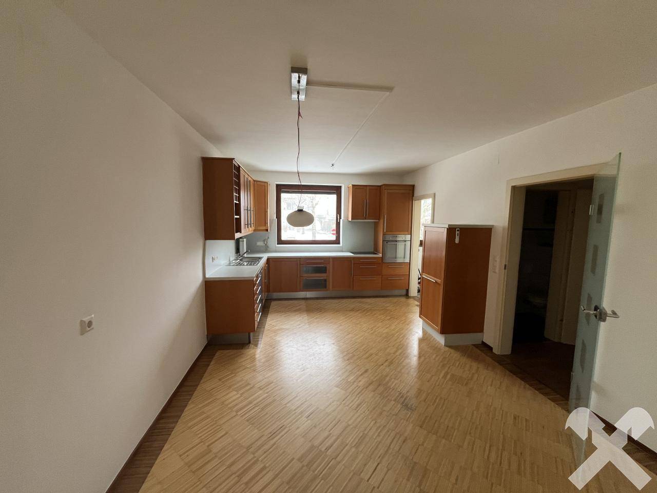 Offene Küche mit Holzeinbauschränken und Parkettboden, bietet viel Platz.