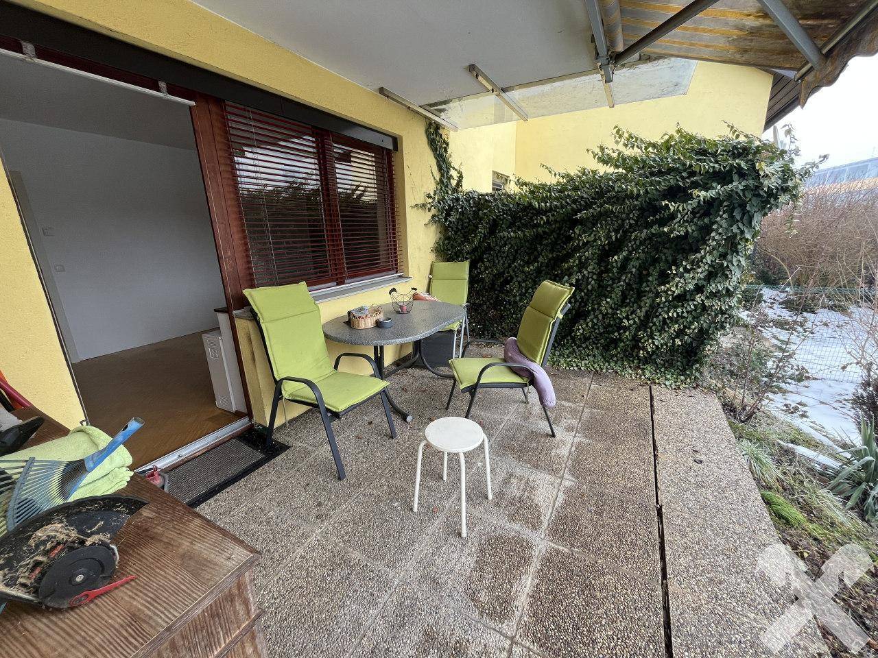 Gemütliche Terrasse mit Gartenmöbeln und üppiger Begrünung.