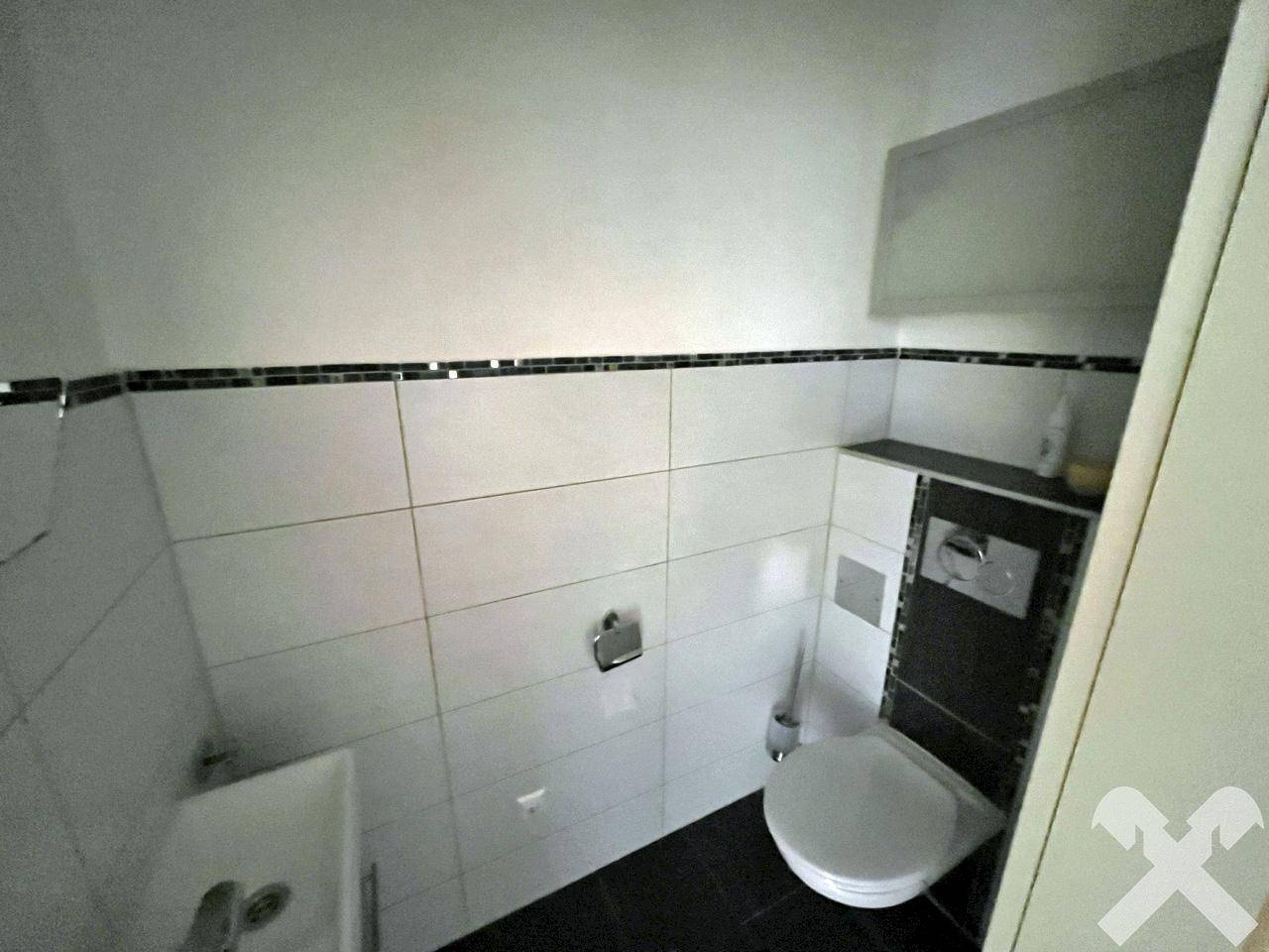 Kleines Gäste-WC mit Wand-WC und Waschbecken.
