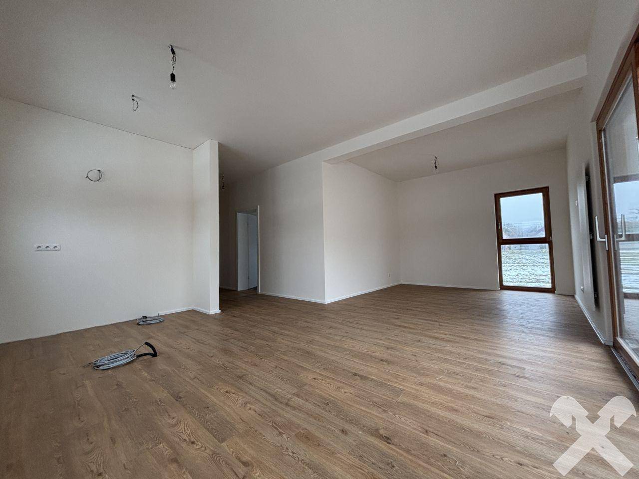 Geräumiger Wohnbereich mit Laminatboden und viel Tageslicht, bereit zum Einrichten.