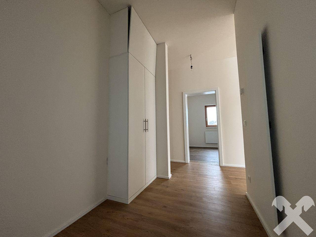 Heller Flur mit Laminatboden und praktischem Einbauschrank, führt zu weiteren Räumen.