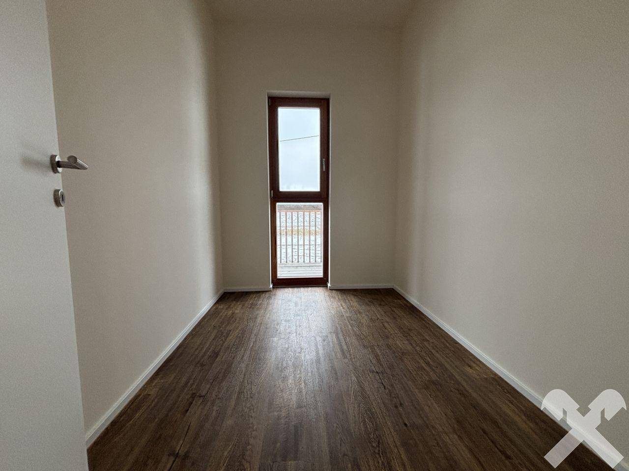 Kleiner Raum mit Laminatboden und französischem Balkon, bietet frische Luft.