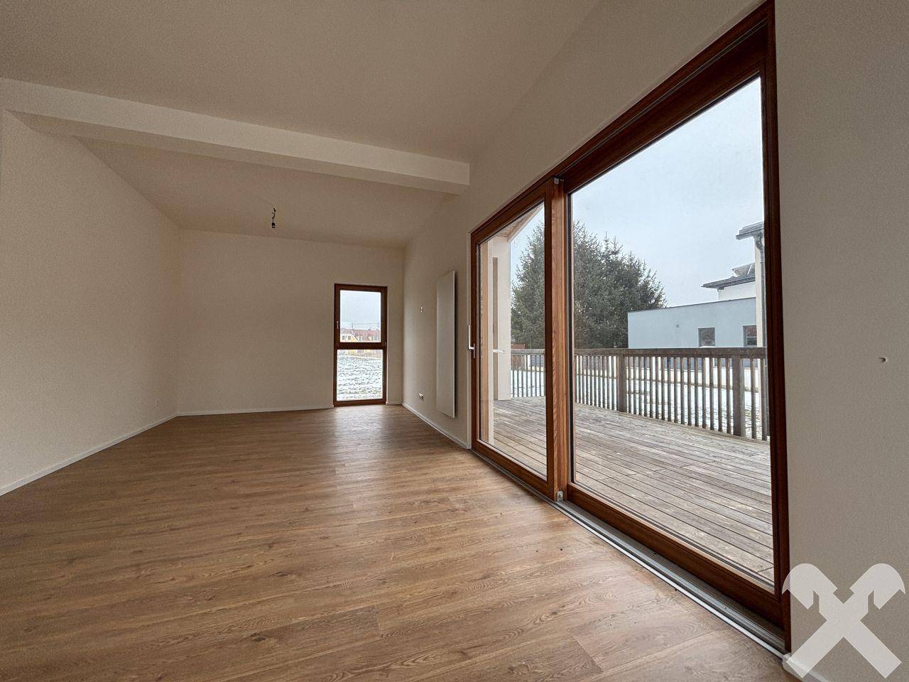 Große Schiebetür im Wohnbereich bietet Zugang zur Holzterrasse und viel Helligkeit.