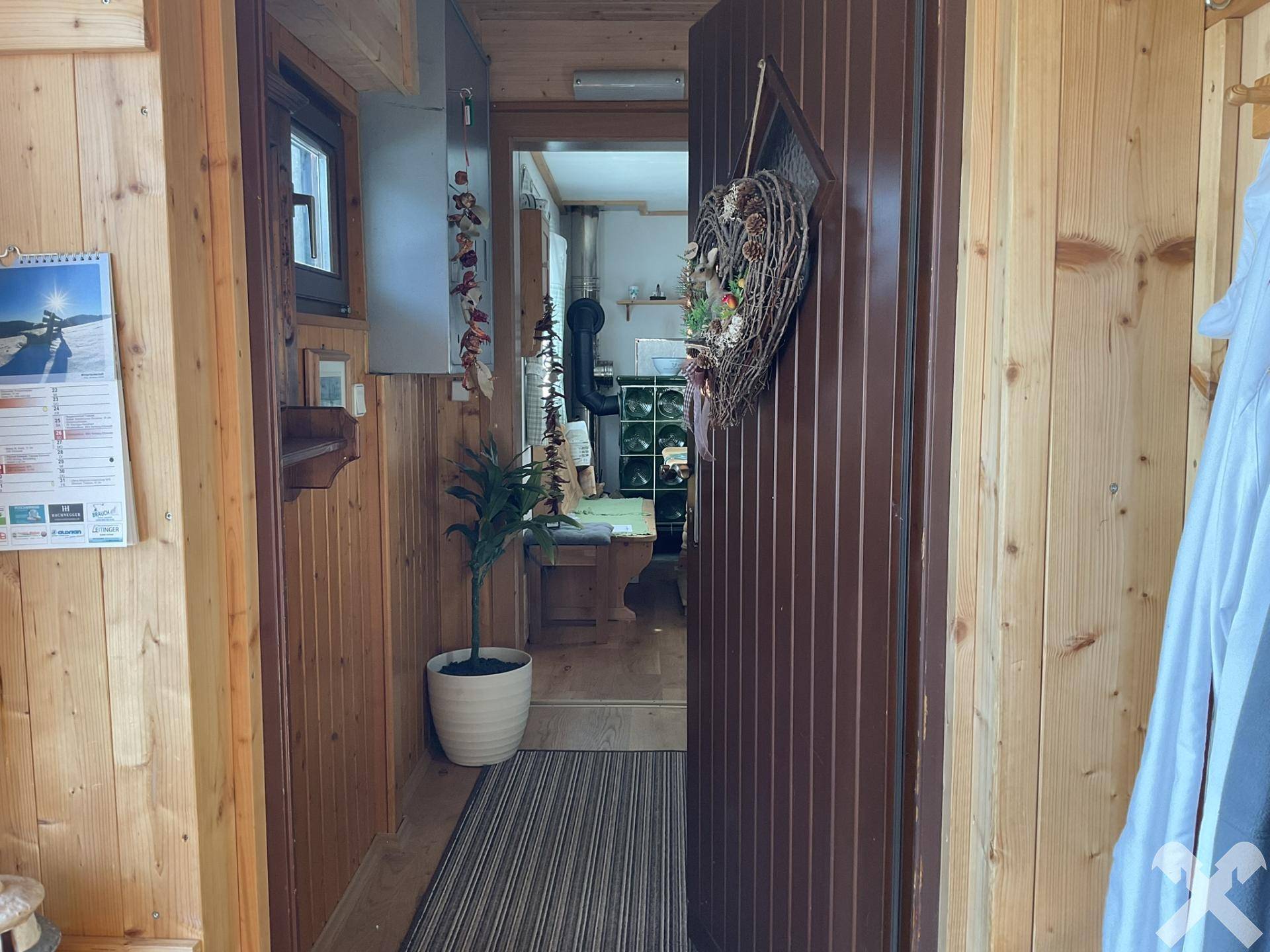 Gemütlicher Eingangsbereich mit Holzvertäfelung und Blick in den angrenzenden Wohnbereich.