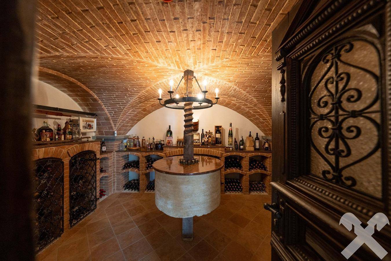 Historischer Weinkeller mit Ziegelgewölbe, Fliesenboden und umfangreicher Weinsammlung.