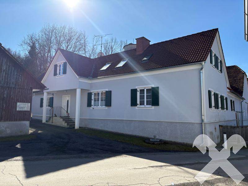 Gut erhaltenes Wohnhaus mit Satteldach, Dachfenstern und gepflegter Fassade an einem sonnigen Tag.