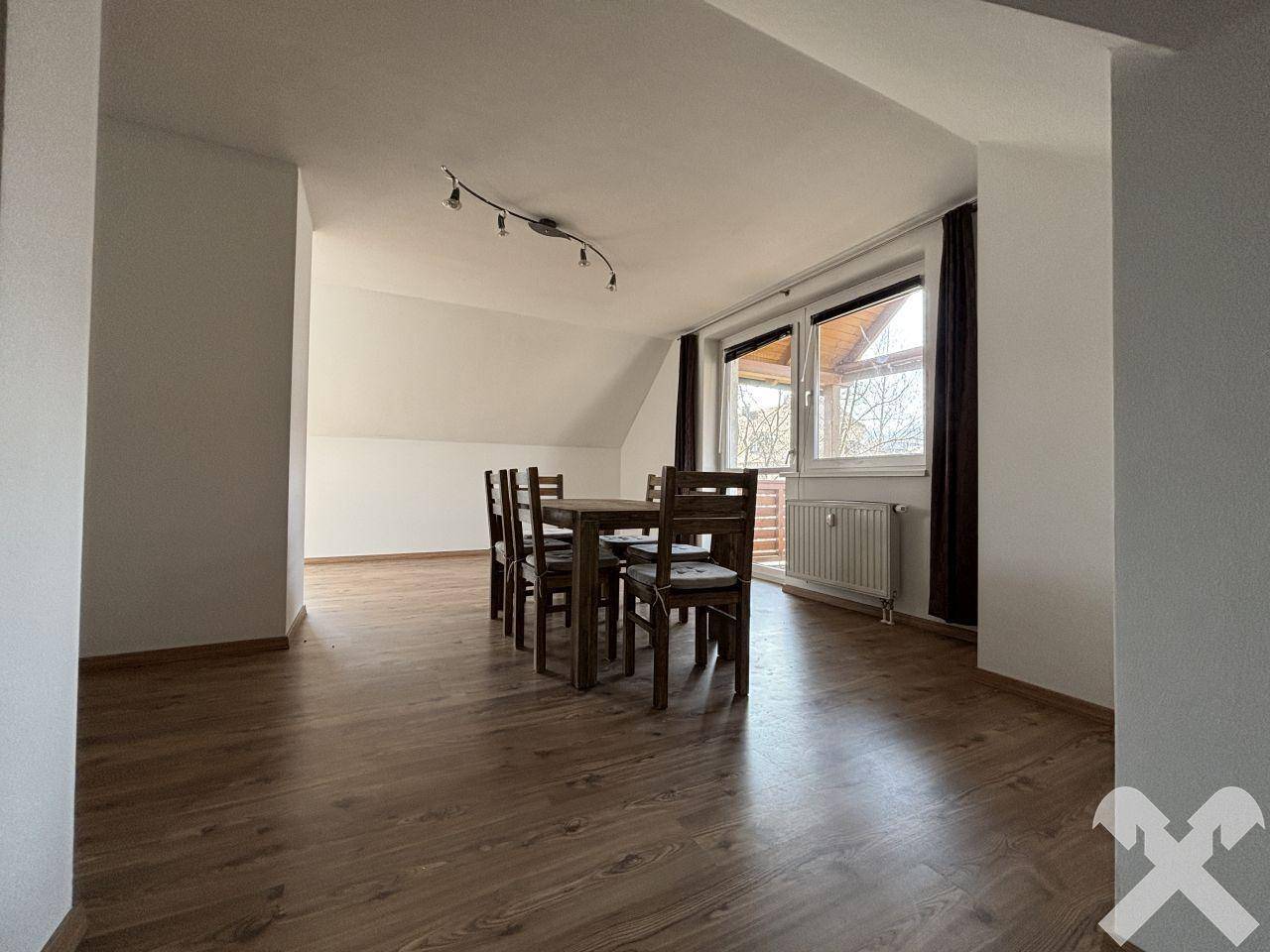 Geräumiger Essbereich mit Holztisch, Stühlen und Zugang zu einem Balkon.