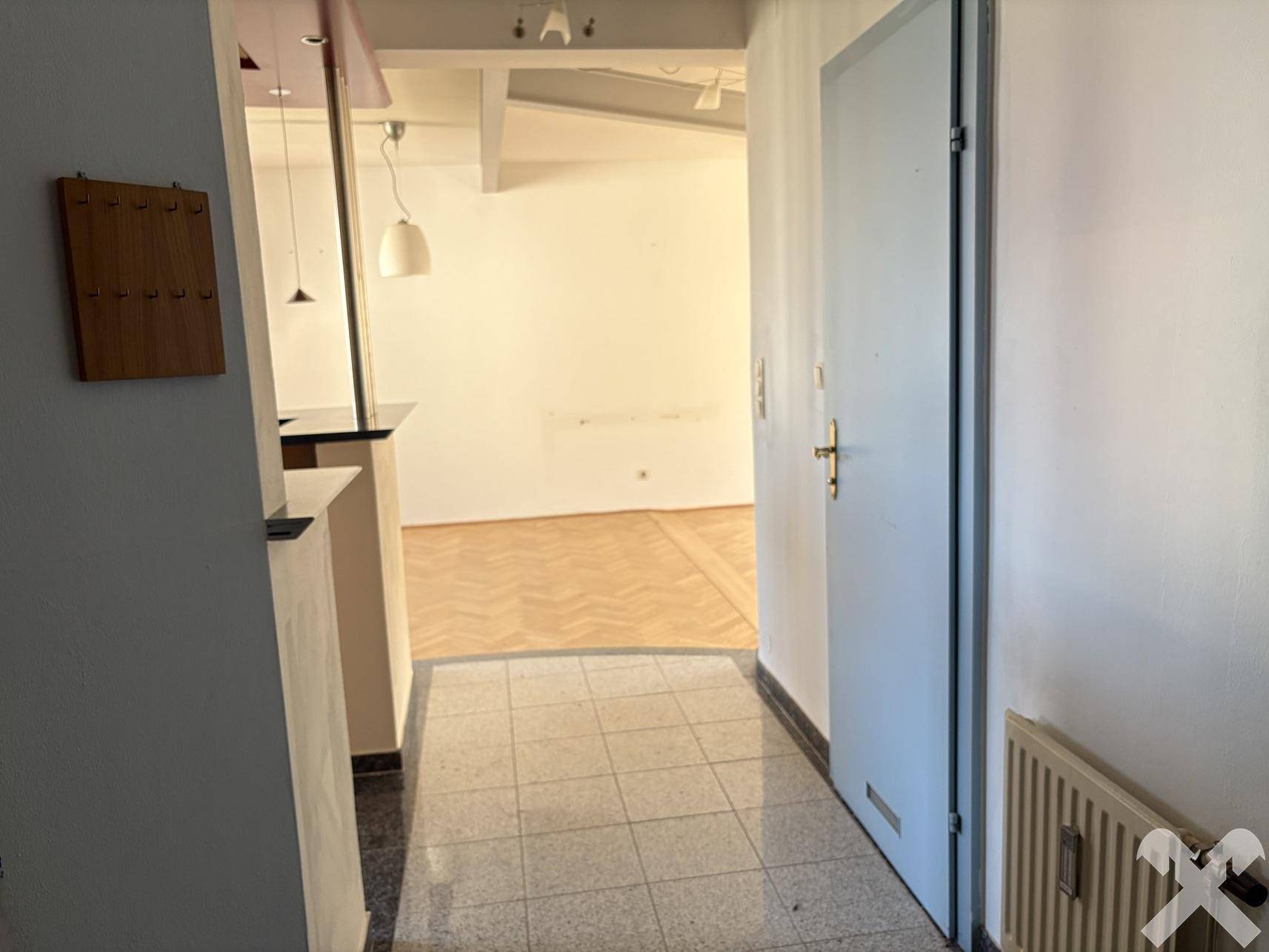 Eingangsbereich mit Fliesenboden und Zugang zum Wohnbereich, hell und einladend.