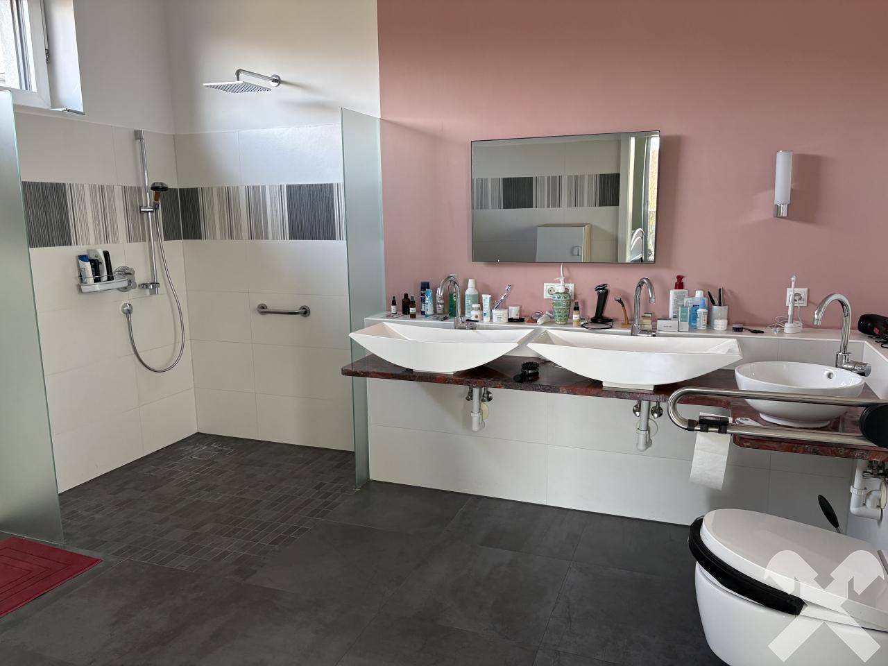 Modernes Badezimmer mit Doppelwaschbecken, großer begehbarer Dusche und farbigen Wänden.