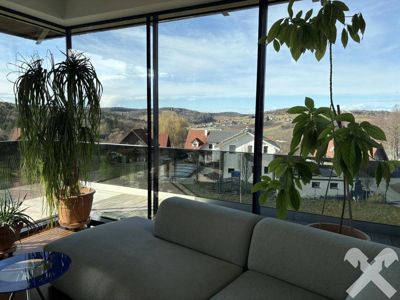 Helles Wohnzimmer mit großen Fensterfronten, die einen weiten Blick in die Landschaft bieten.