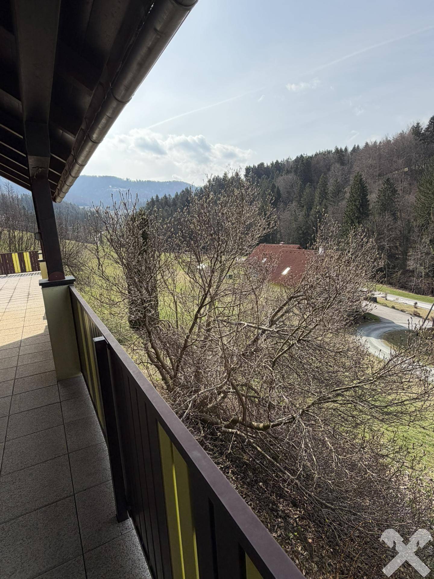 Balkon mit weitem Blick über die grüne Landschaft und die umliegenden Wälder.