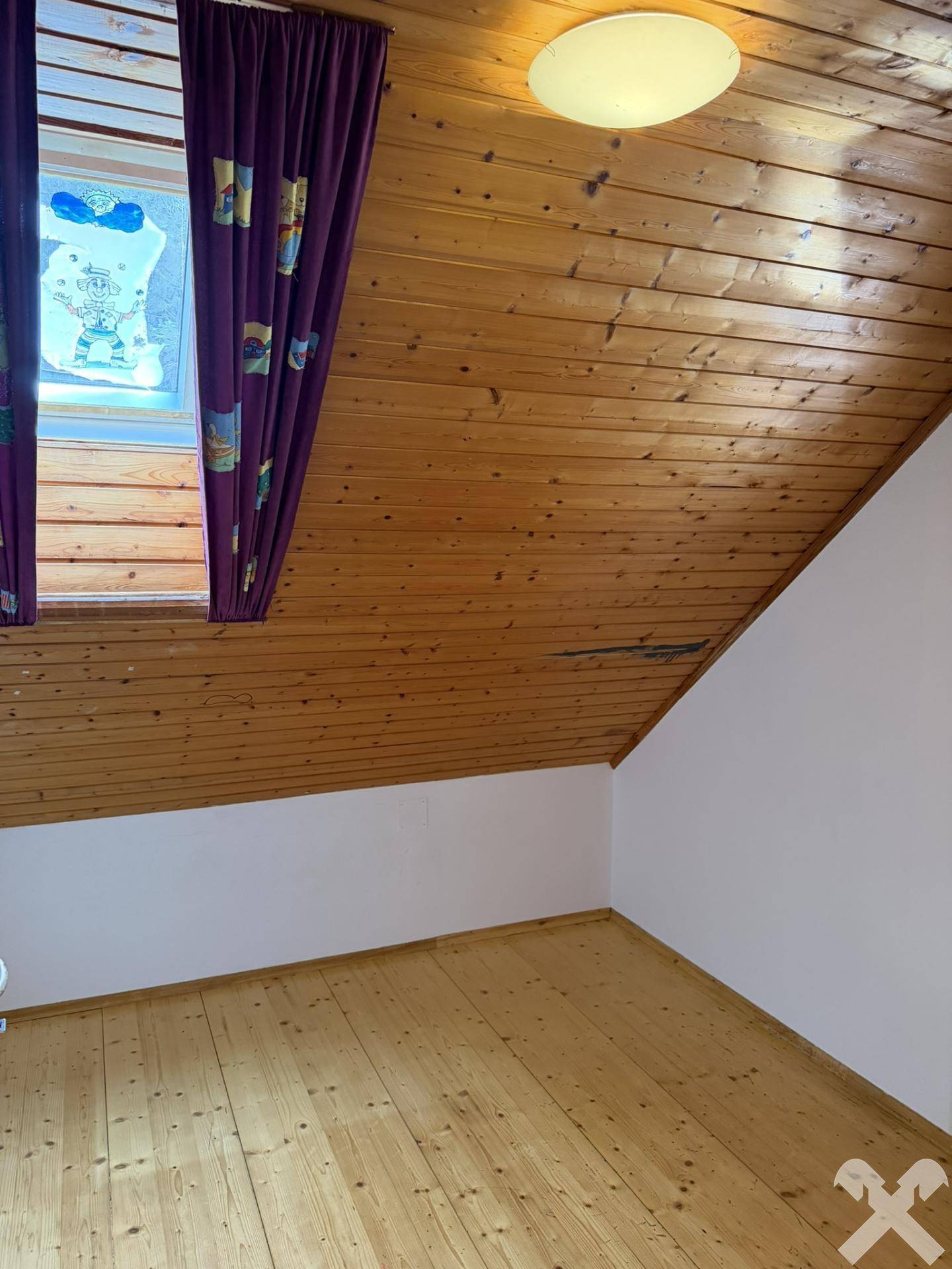Schlafzimmer im Dachgeschoss mit Holzverkleidung an Decke und Wänden, sowie Holzboden.