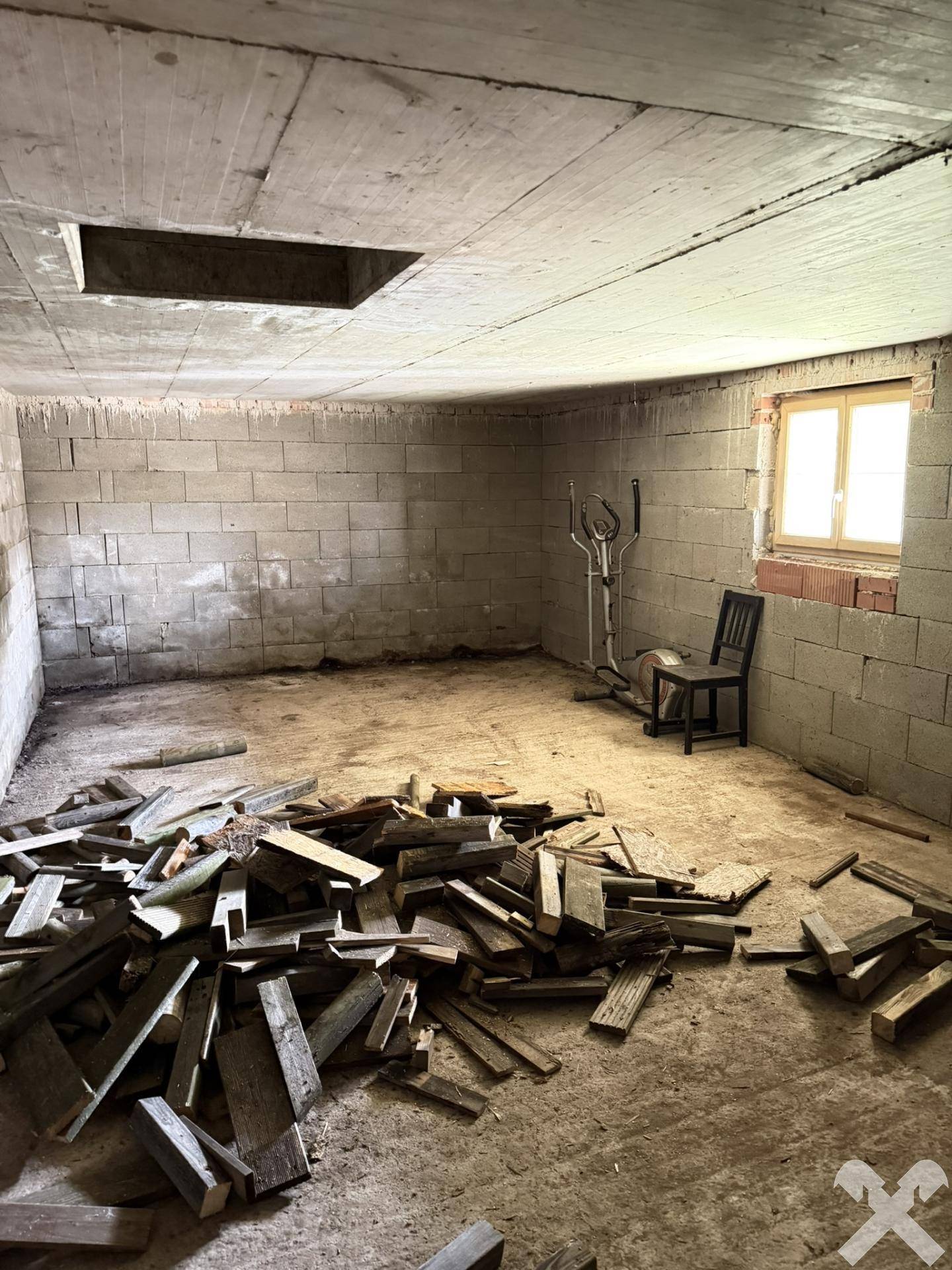 Unfertiger Kellerraum mit Betonwänden und Fenster, bietet viel Stauraum.