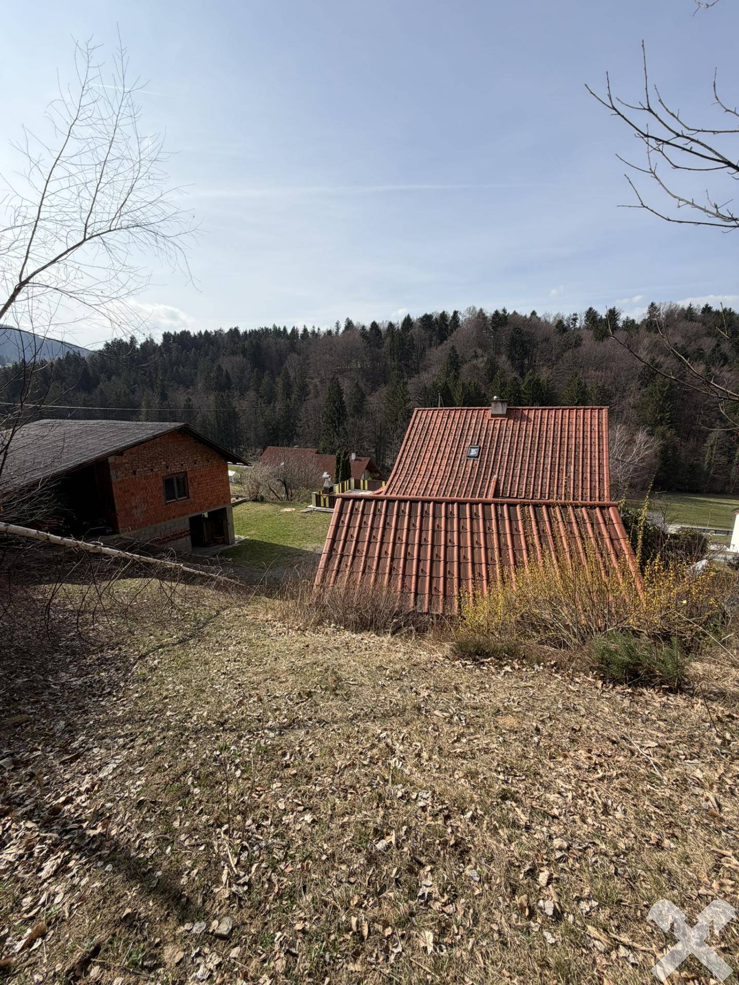 Blick von einem erhöhten Punkt auf das Anwesen mit Haupt- und Nebengebäude.