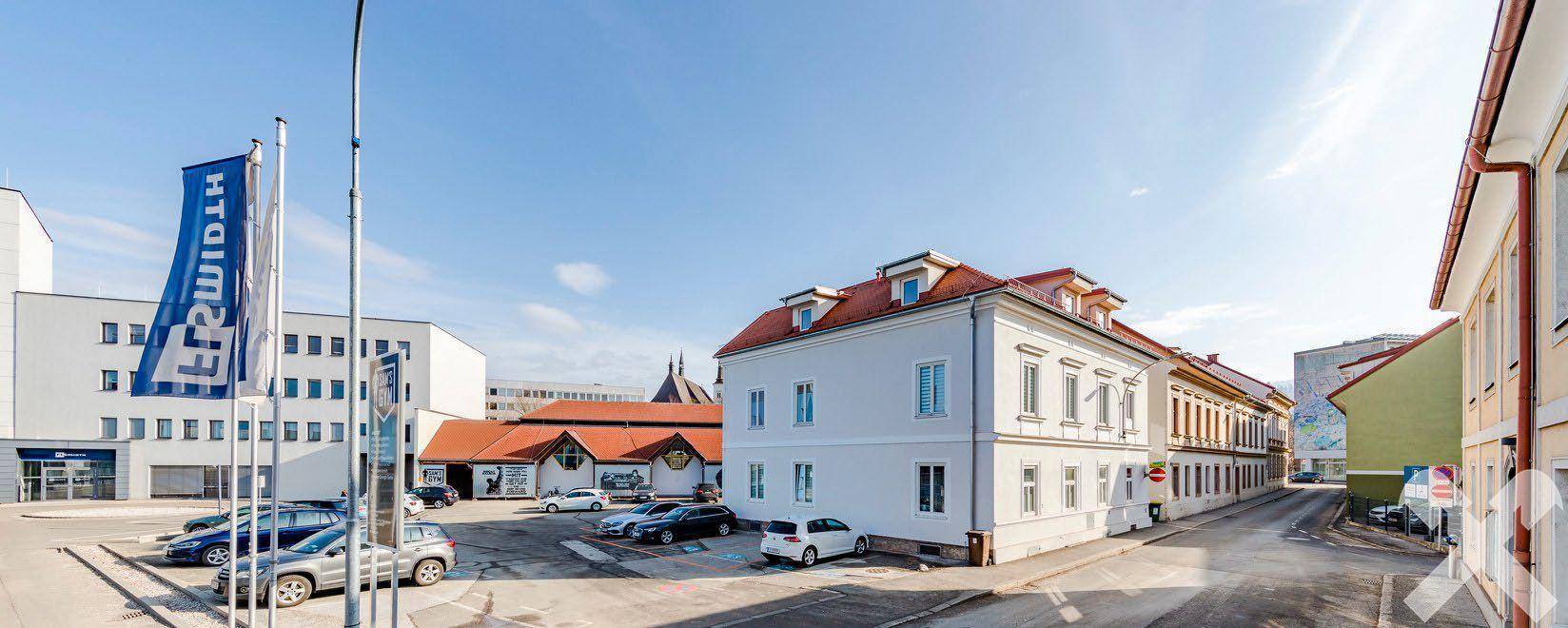 Weitwinkelaufnahme eines Gewerbegebiets mit mehreren Gebäuden und einem großen Parkplatz.
