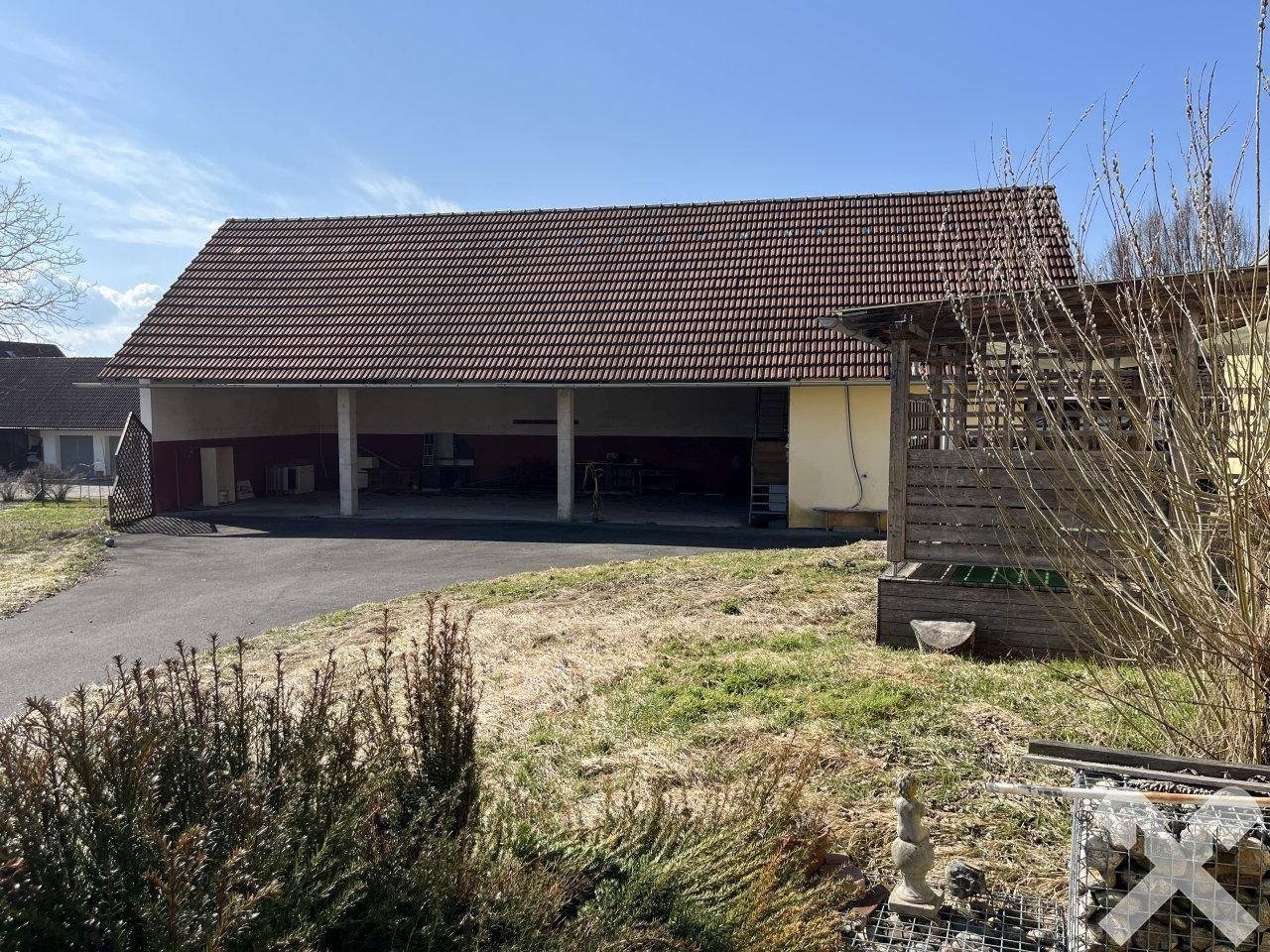 Geräumige offene Garage oder Carport-Struktur mit großem Dach und viel Platz für Fahrzeuge.