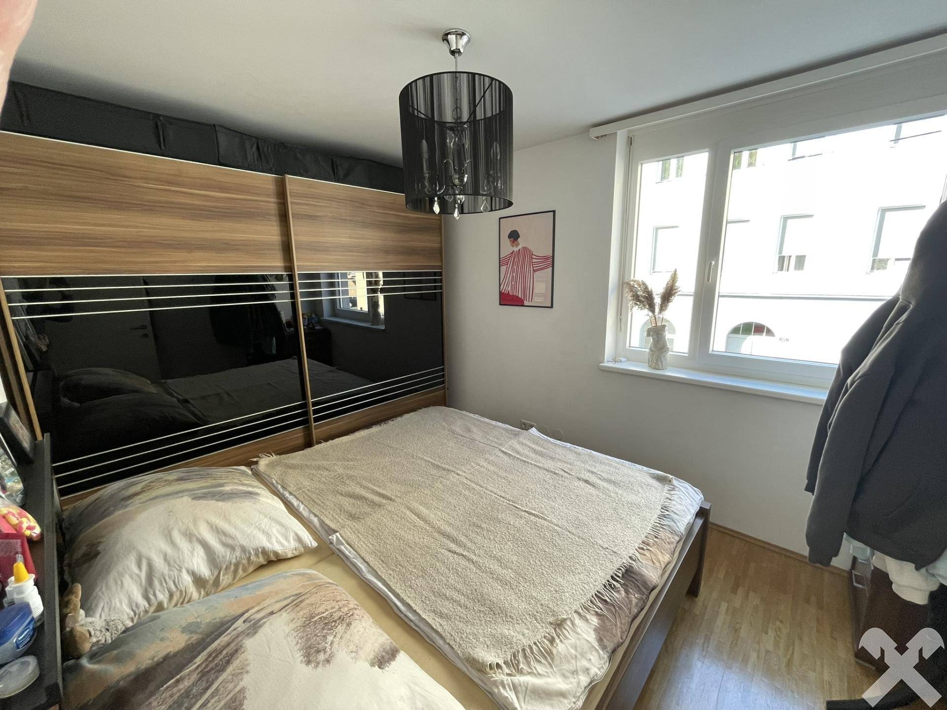 Gemütliches Schlafzimmer mit Doppelbett, großem Kleiderschrank und hellem Fenster.