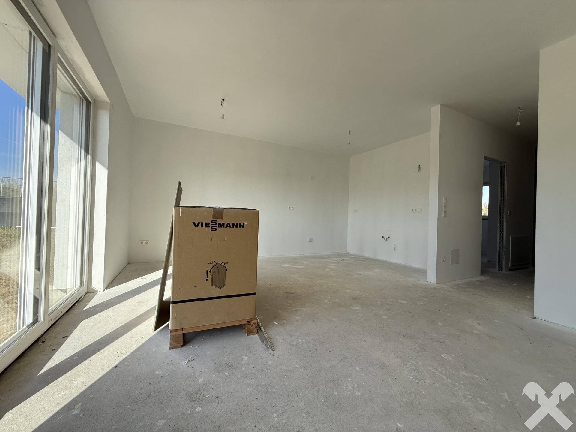 Heller Wohnbereich im Neubau mit großen Fenstern und viel Tageslicht.