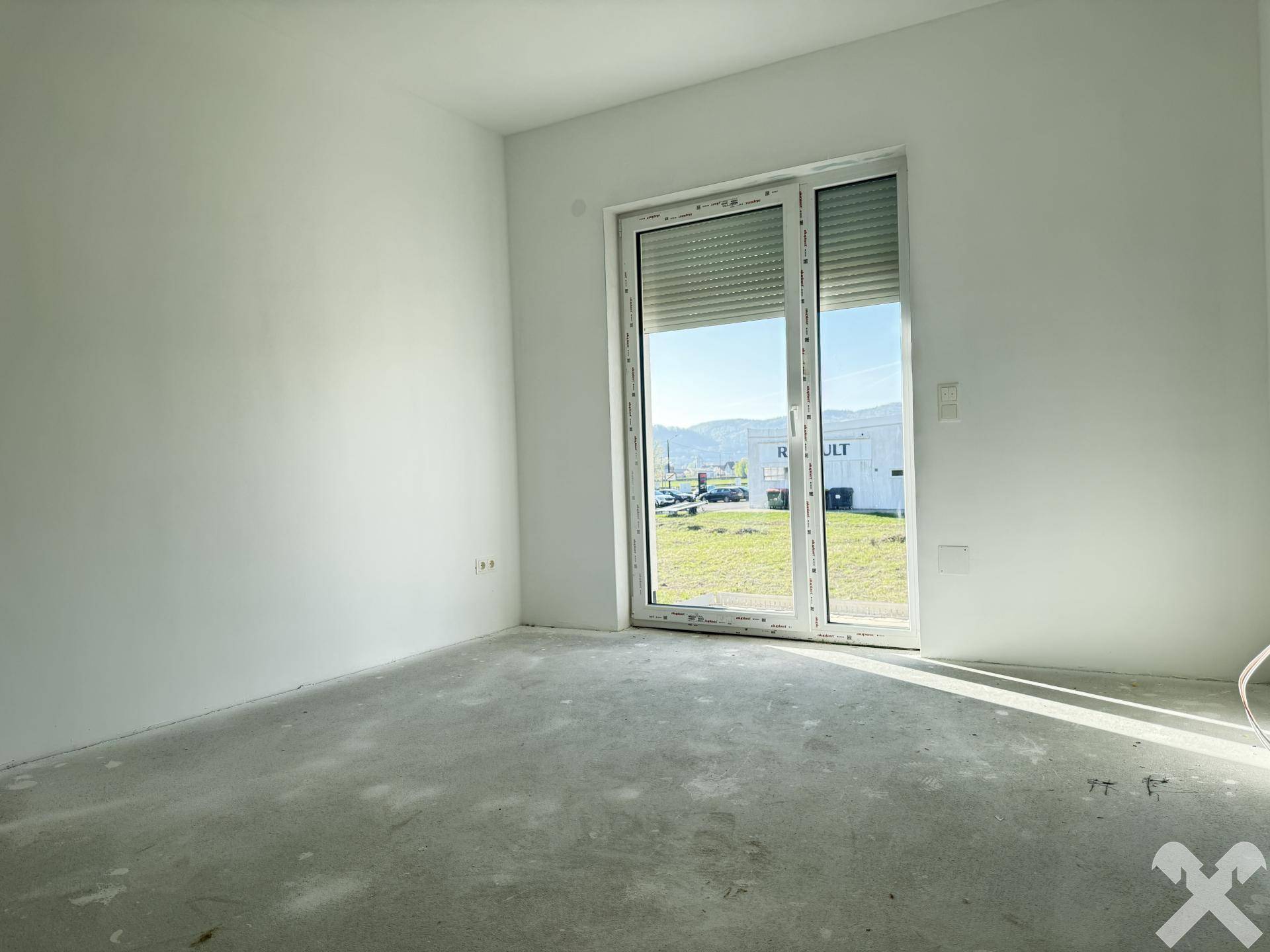 Zimmer mit großem Schiebefenster und Zugang zum Außenbereich im Neubau.