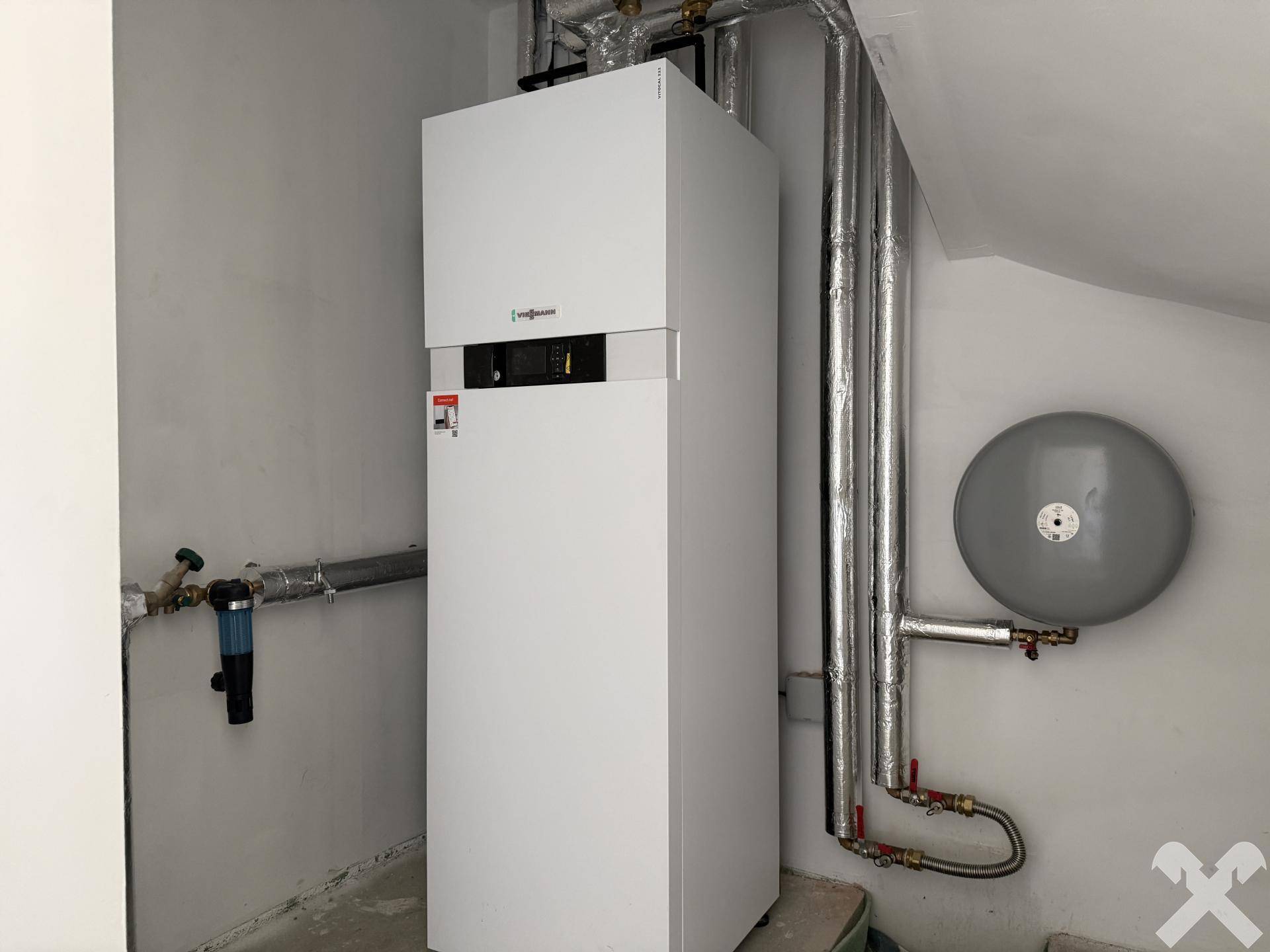 Moderner Heizkessel und Warmwasserspeicher in einem Technikraum.