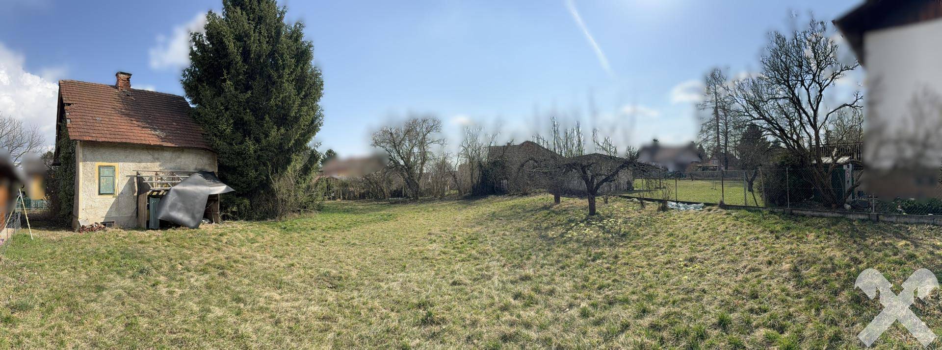 Panoramablick auf das alte Haus und den weitläufigen Garten mit verschiedenen Bäumen.