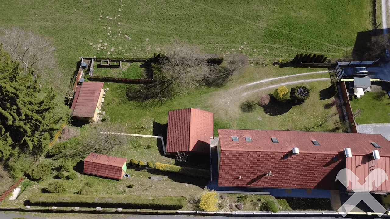 Weitläufige Luftaufnahme des Anwesens mit grünen Feldern, Nebengebäuden und Gartenbereichen.
