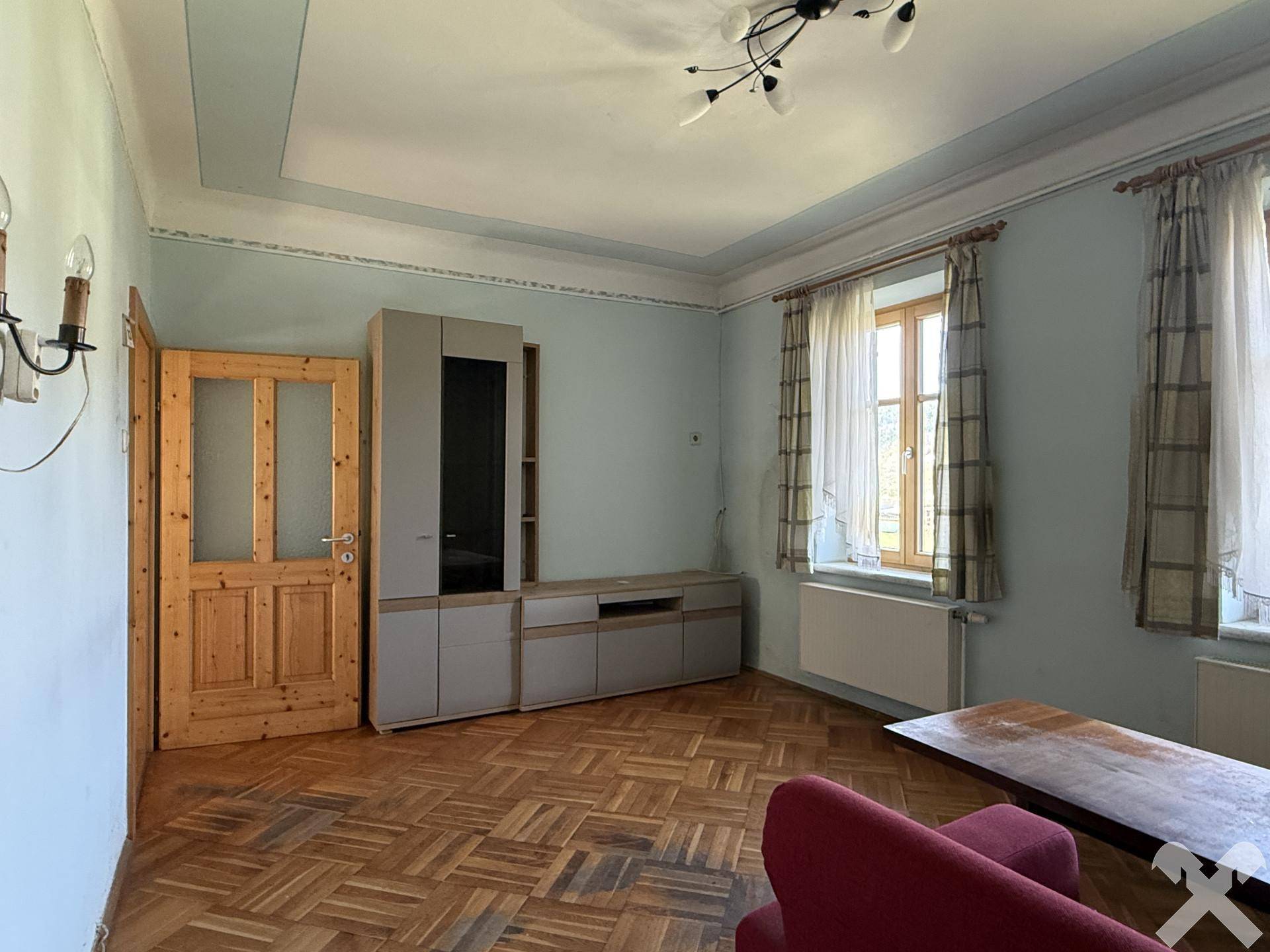 Wohnzimmer mit Parkettboden, moderner Medienwand und hohen Decken, hell und geräumig.