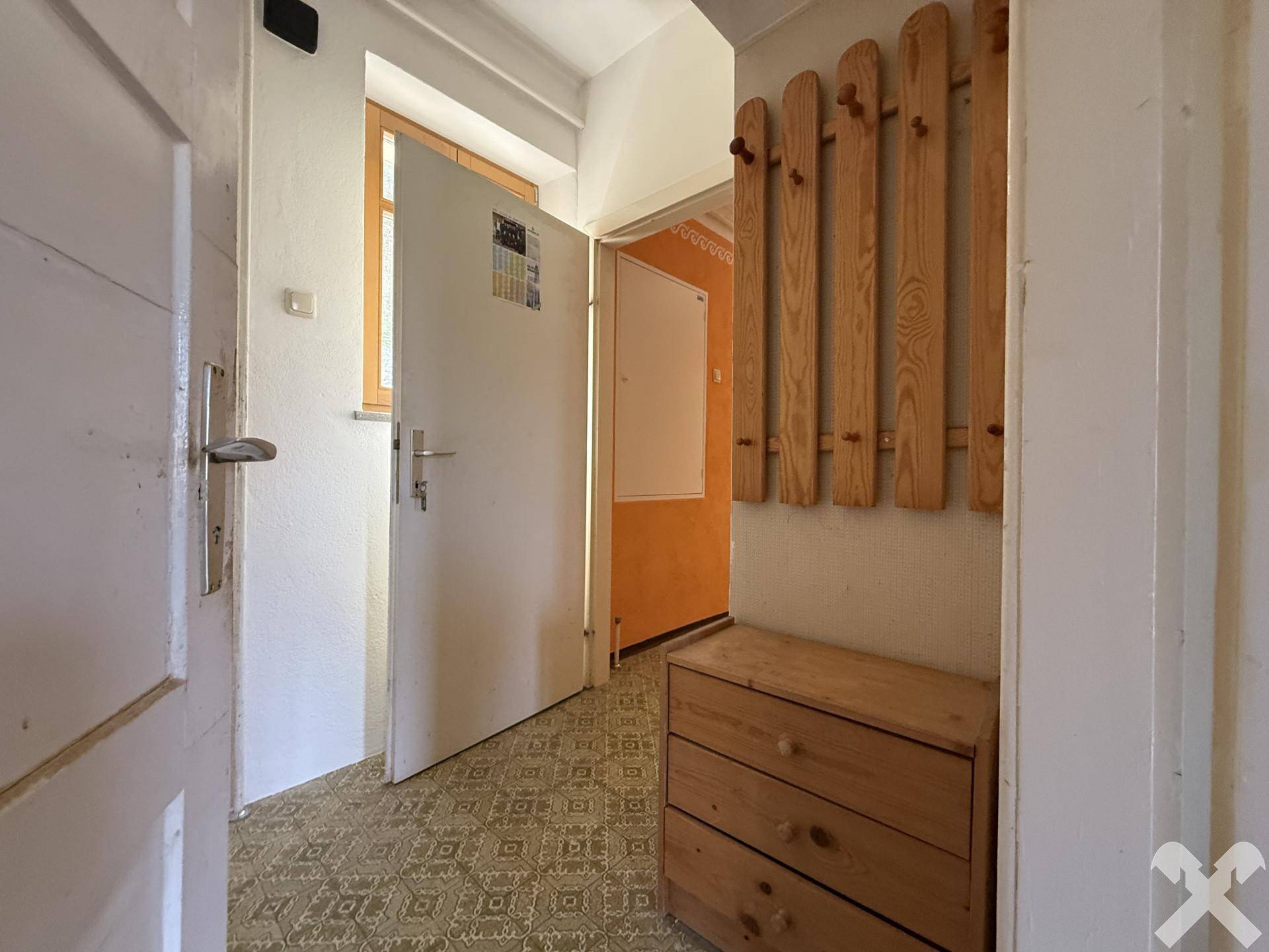 Eingangsbereich mit Garderobe und Fliesenboden, bietet praktischen Stauraum.