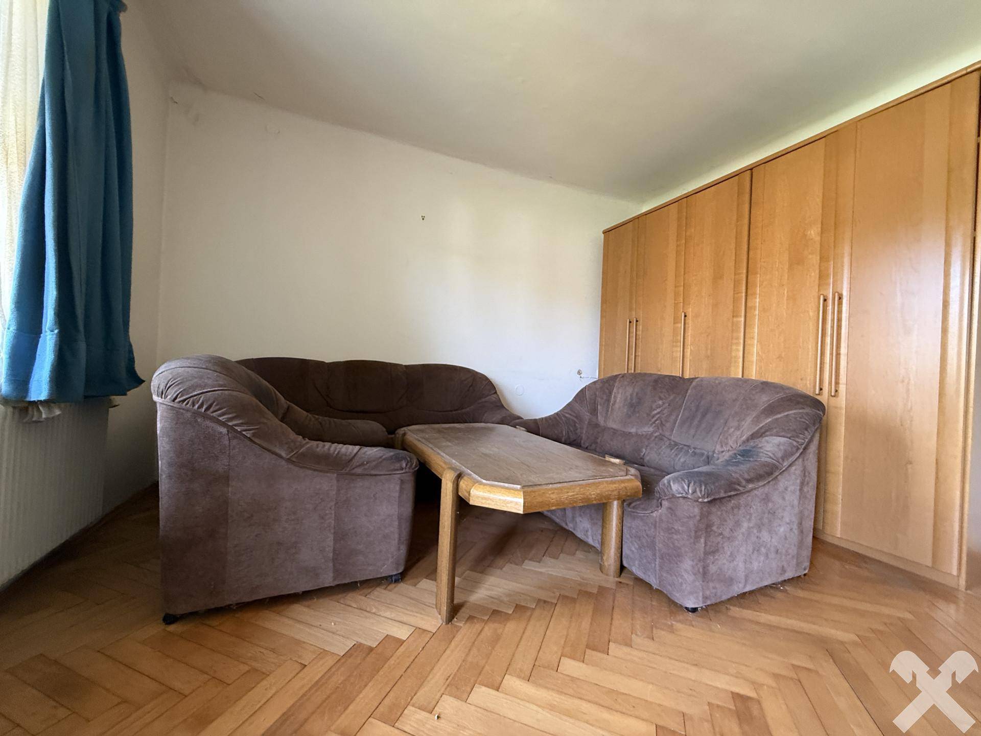 Wohnzimmer mit bequemen Sofas und großen Einbauschränken, ideal für Entspannung.
