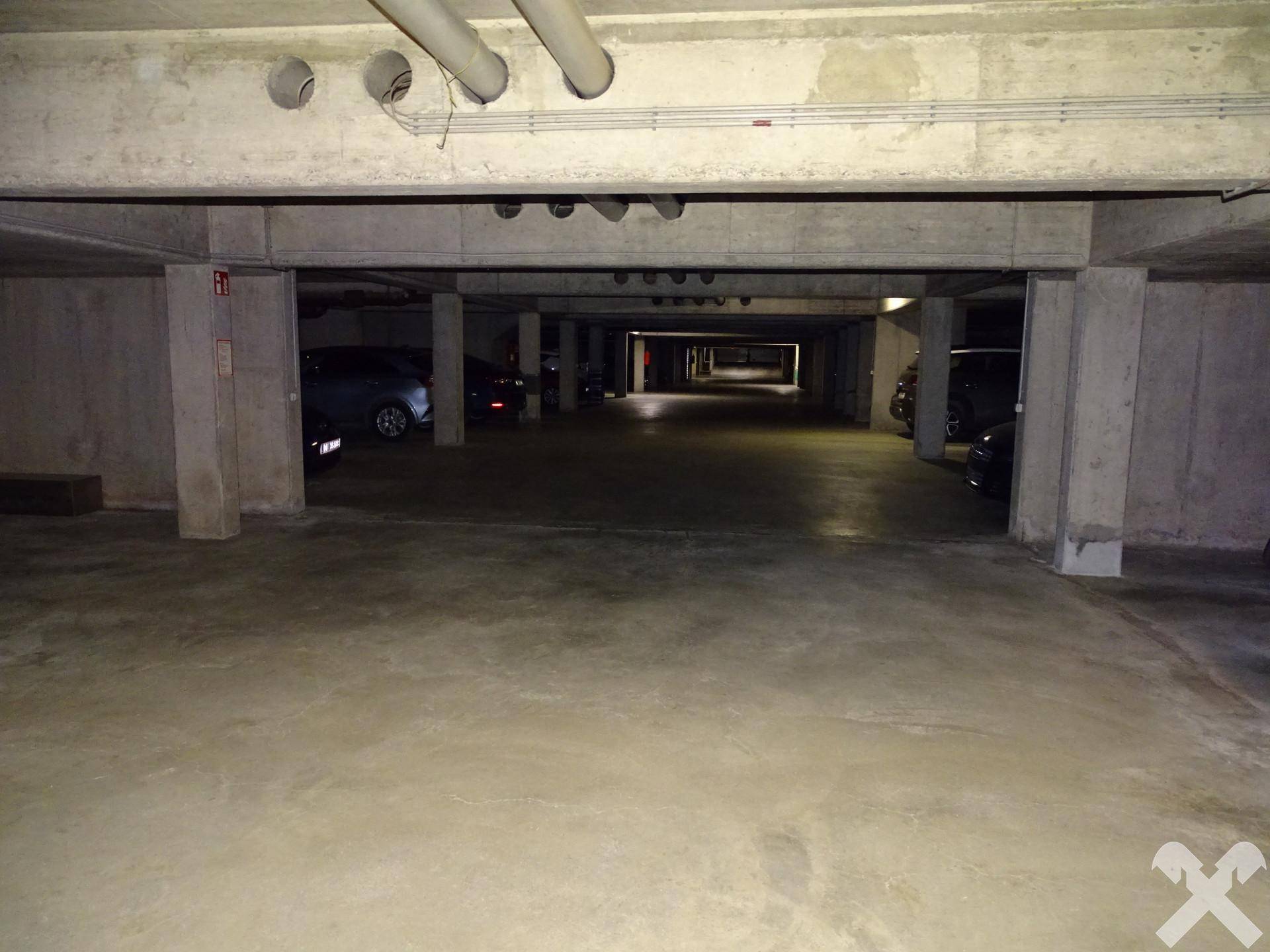 Tiefgarage mit Betonpfeilern und ausreichend Stellplätzen für Fahrzeuge.