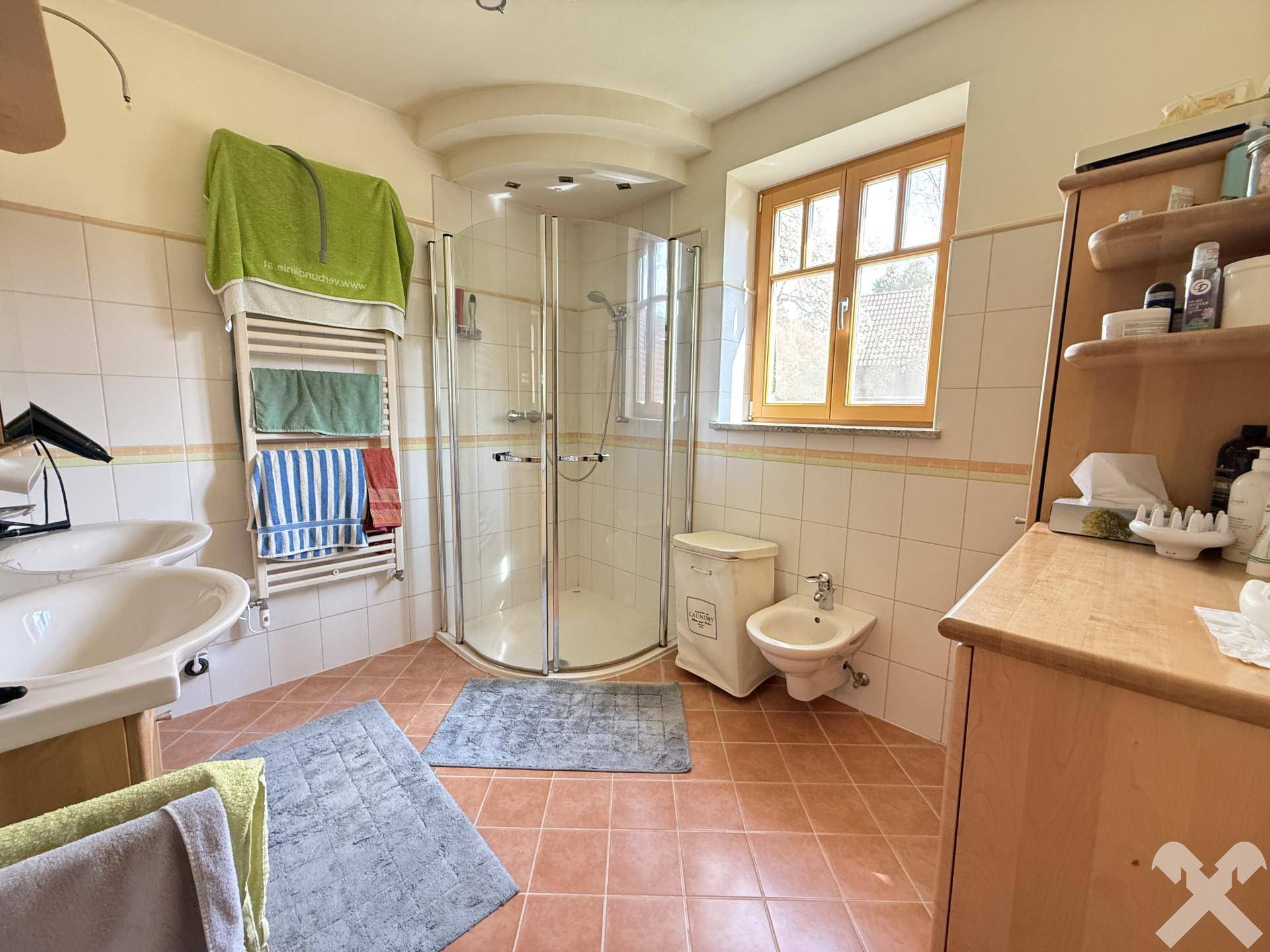 Geräumiges Badezimmer mit Terrakotta-Fliesen, Duschkabine, Doppelwaschbecken und Bidet.